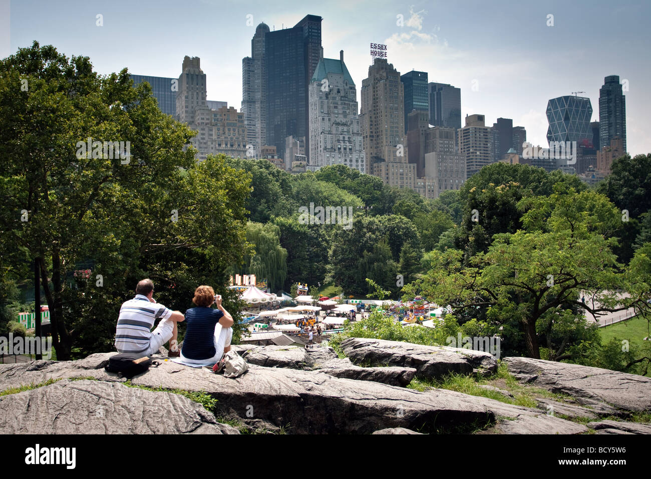 Central Park in New York. Couple sitting on a stone and looks at the Central Park and panorama city. Stock Photo