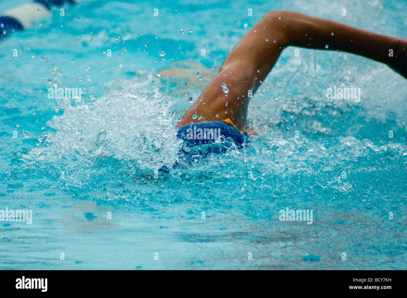 Teen male in swim cap in midstroke Stock Photo Alamy
