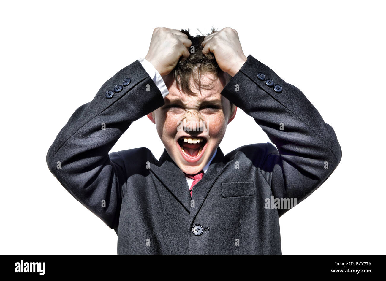 Young boy in suit pulling his hair. Isolated image over white. Angry expression with twinged eyes and open mouth. Stock Photo