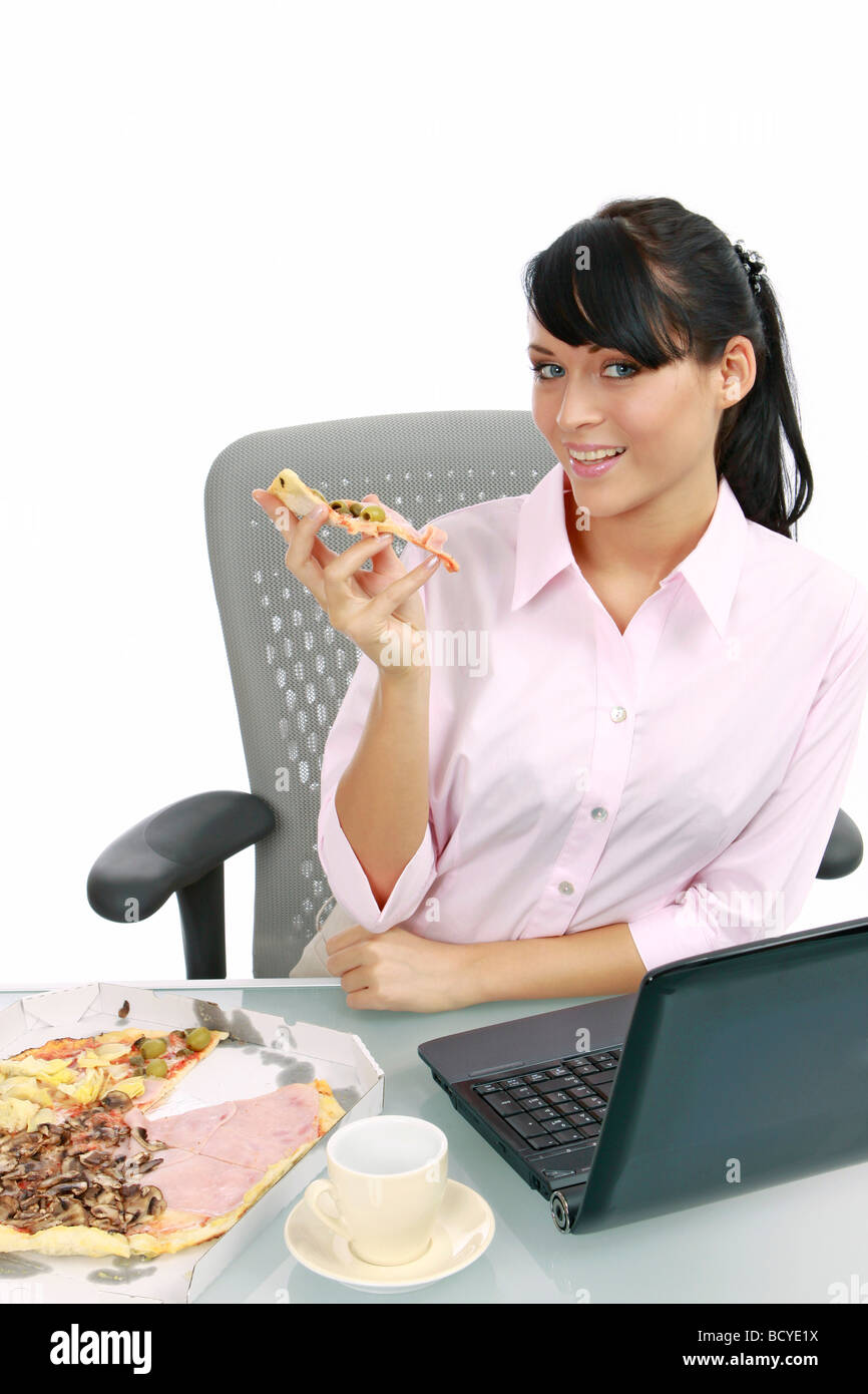 Junge Frau isst Pizza im Buero Businesswoman eating pizza in the office Stock Photo