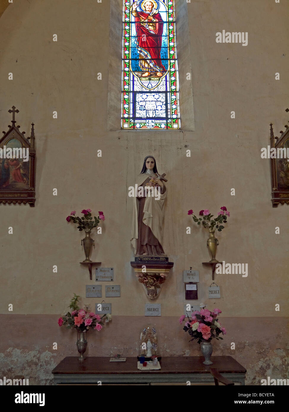 St Therese at sculpture on the wall with pictures in the church of Castelfranc in France Stock Photo