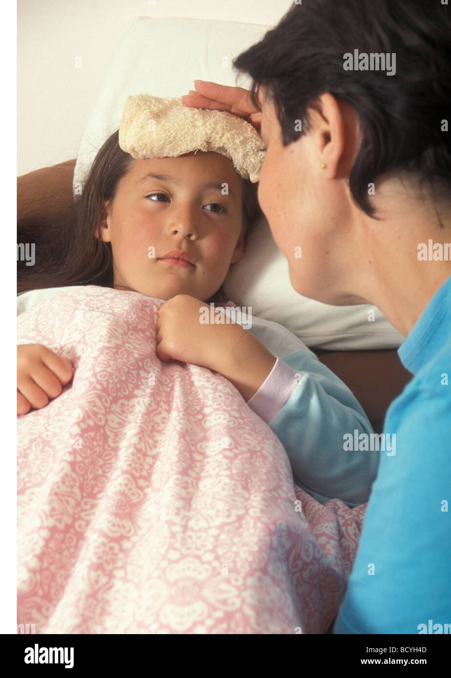 mother wiping sick child s forehead with wash cloth Stock Photo Alamy