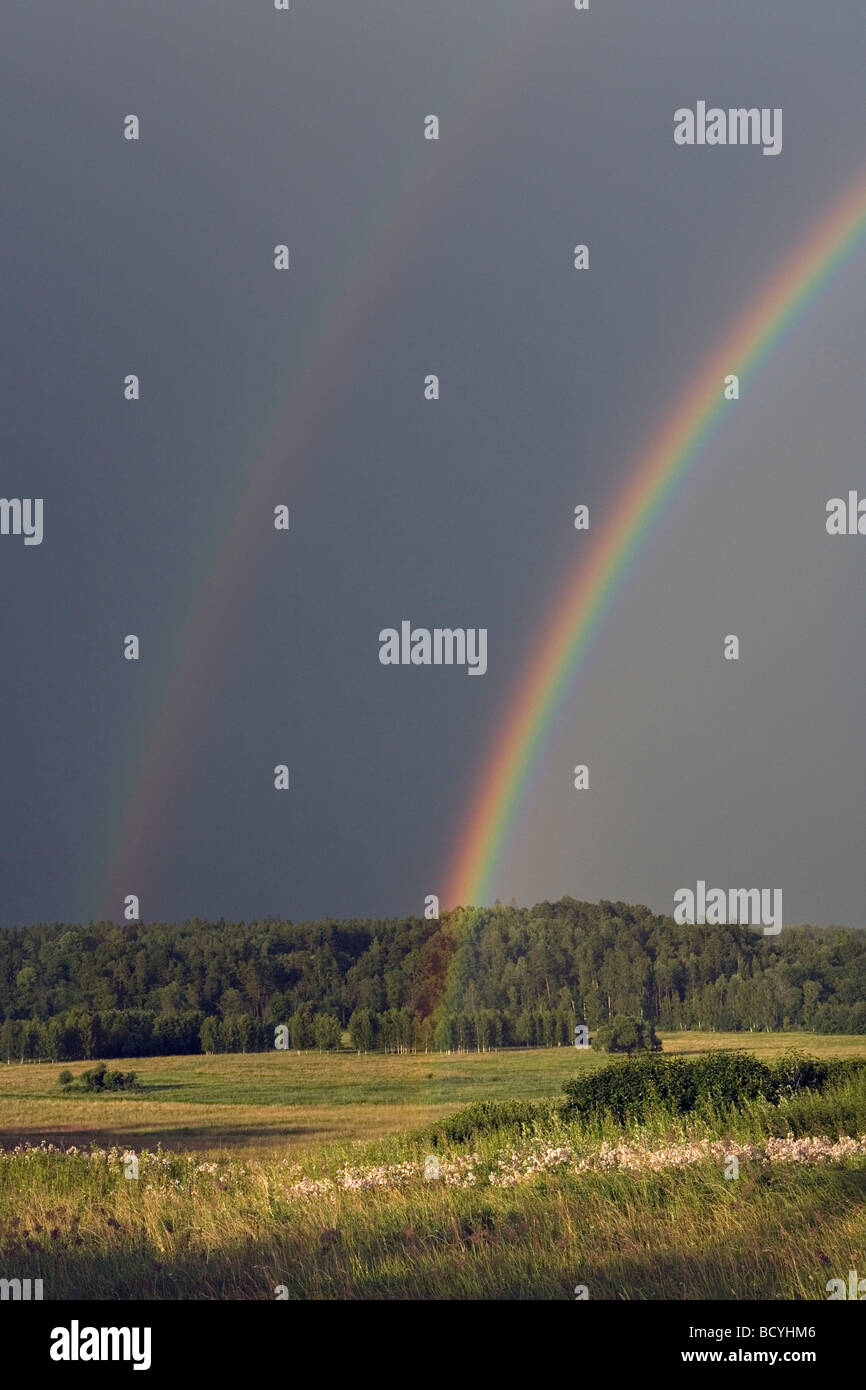 Bright primary and secondary rainbows over Gauja Valley in Gaujiena Latvia Stock Photo