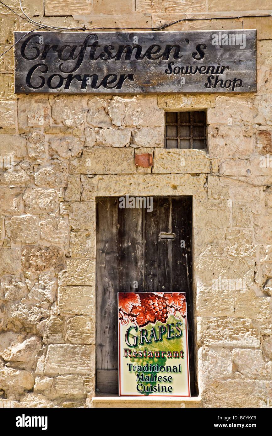 Entrance to Craftsmen's Corner, a souvenir shop in Rabat, Malta, EU. Also a board advertising Grapes Restaurant. Stock Photo