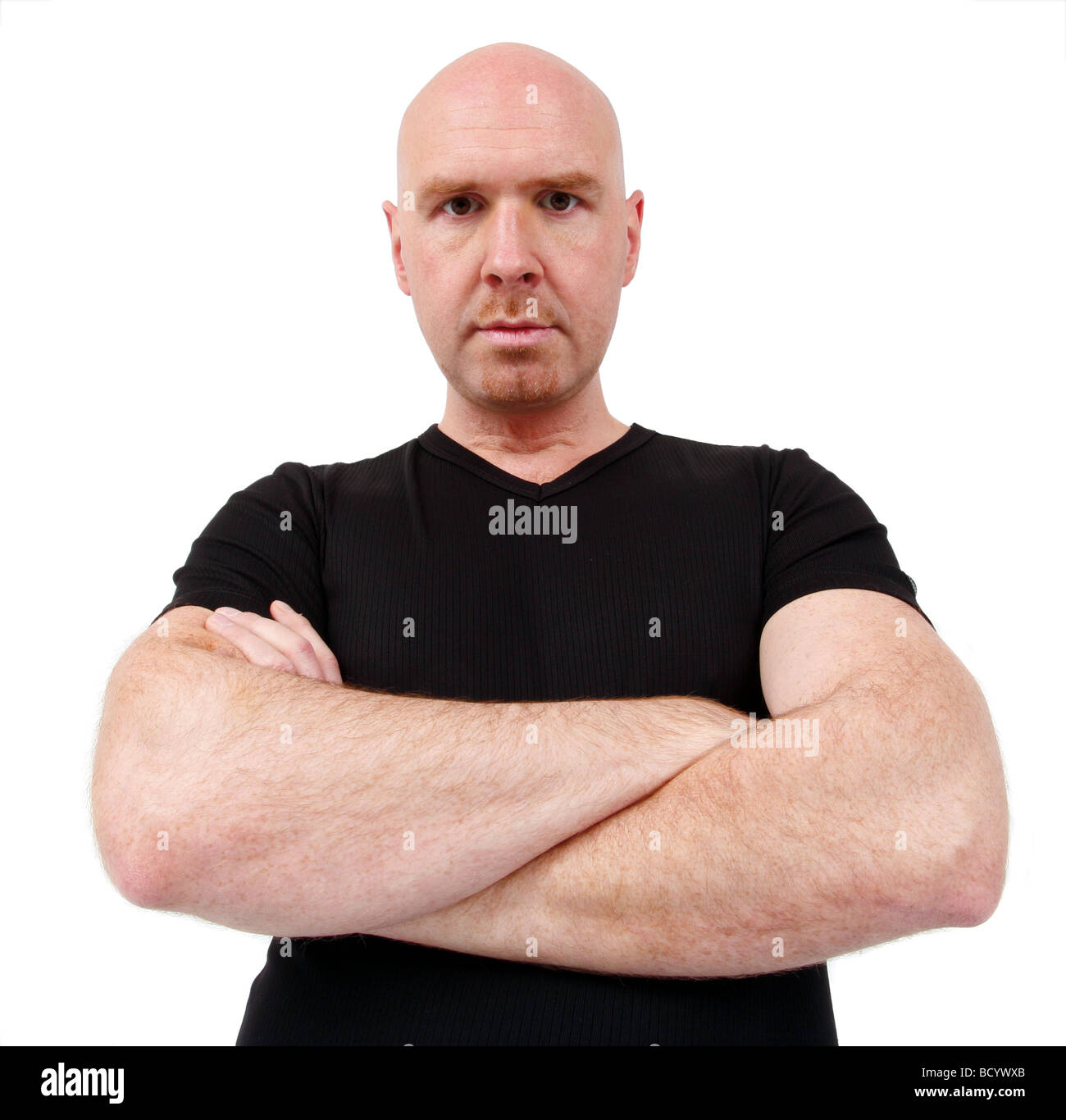 bald headed young bouncer looking angry into the camera Stock Photo