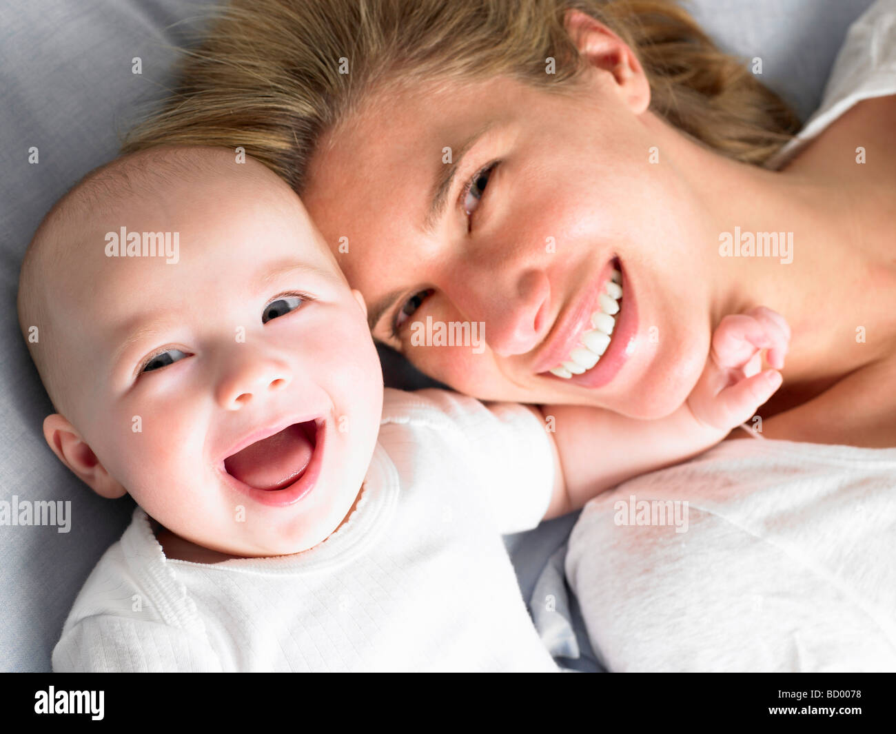 Baby and mother on bed, shot from above Stock Photo