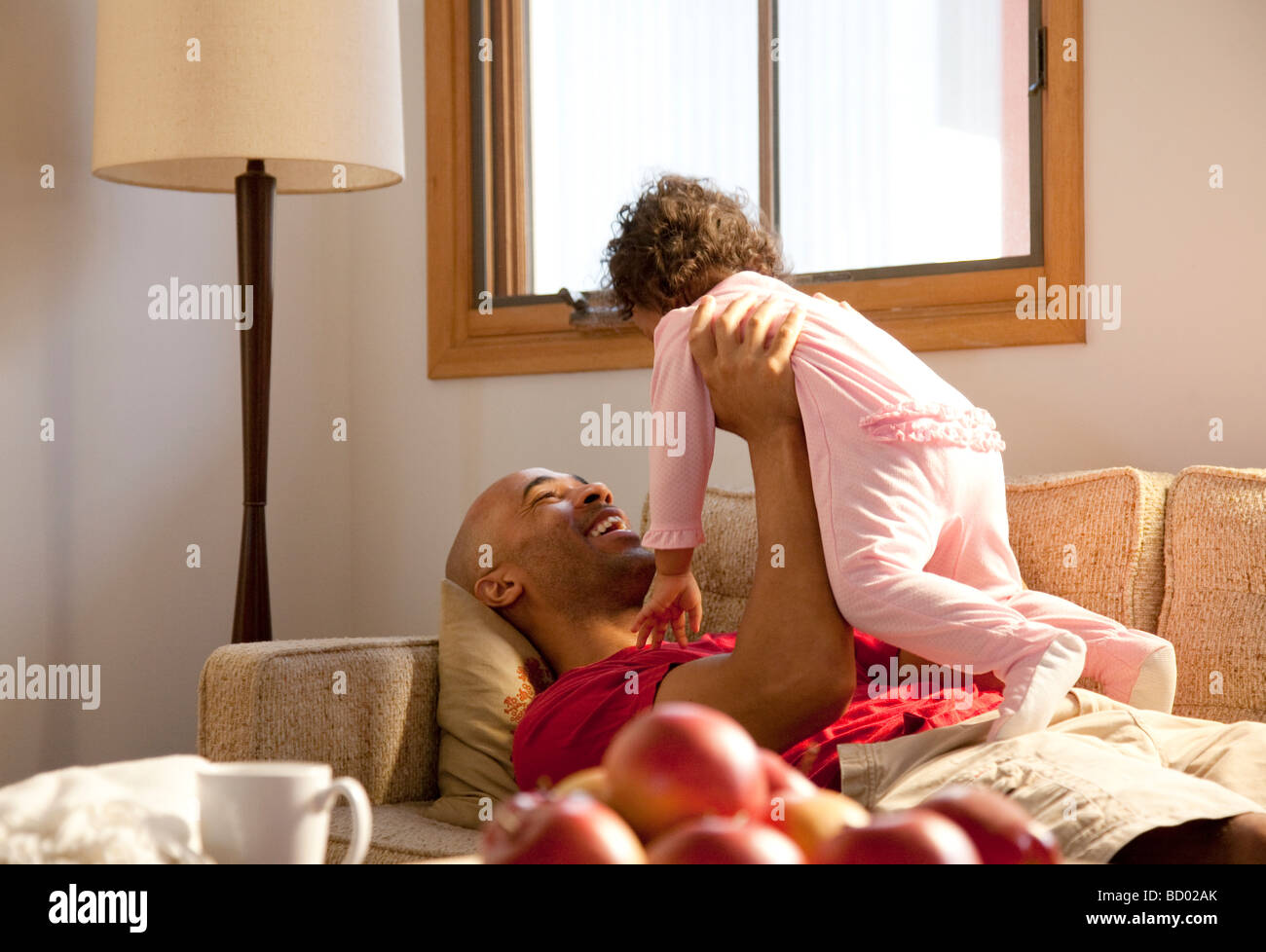 Dad and Child play on the couch Stock Photo