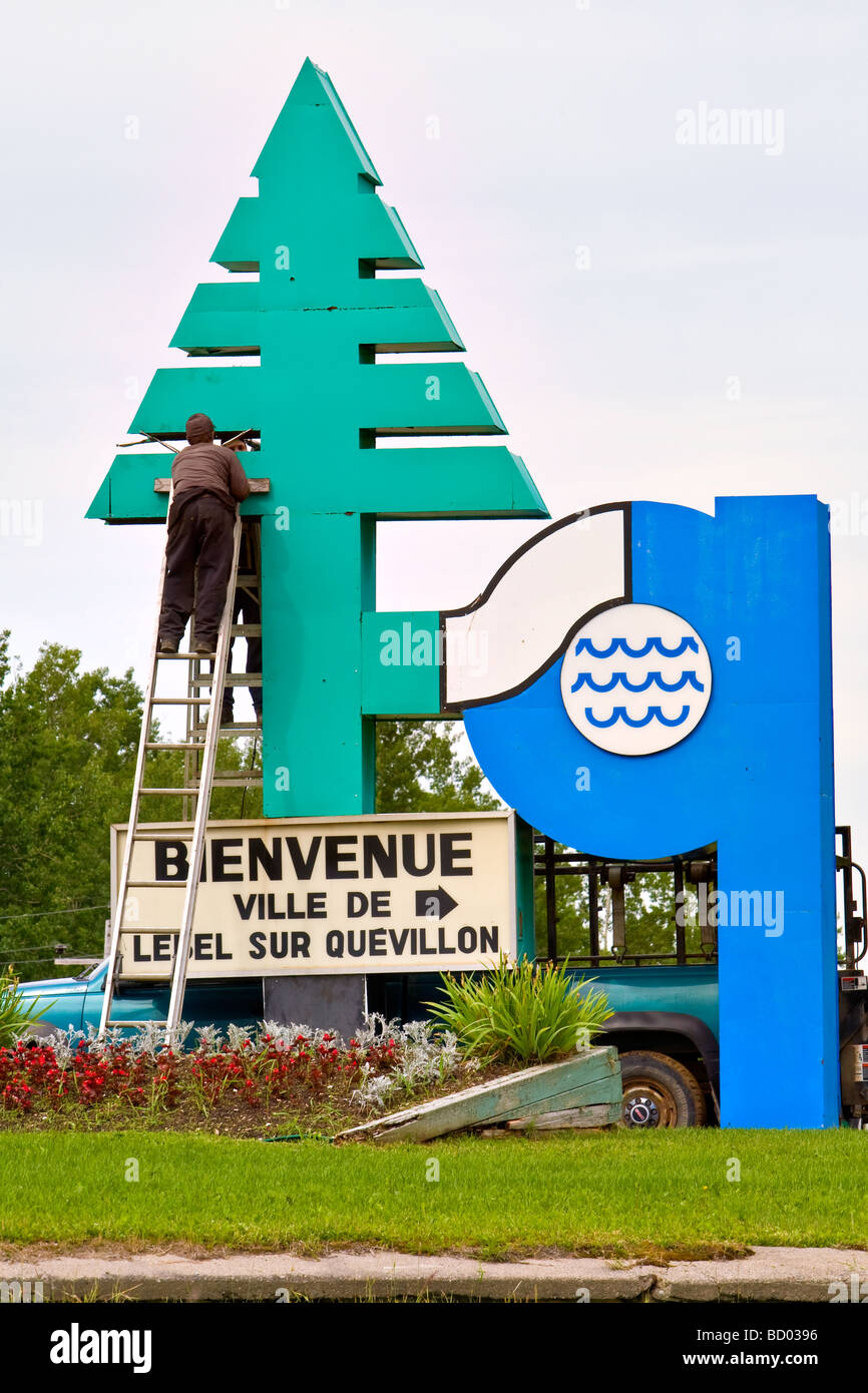 Employees work on a sign travelers to the town of Lebel Sur