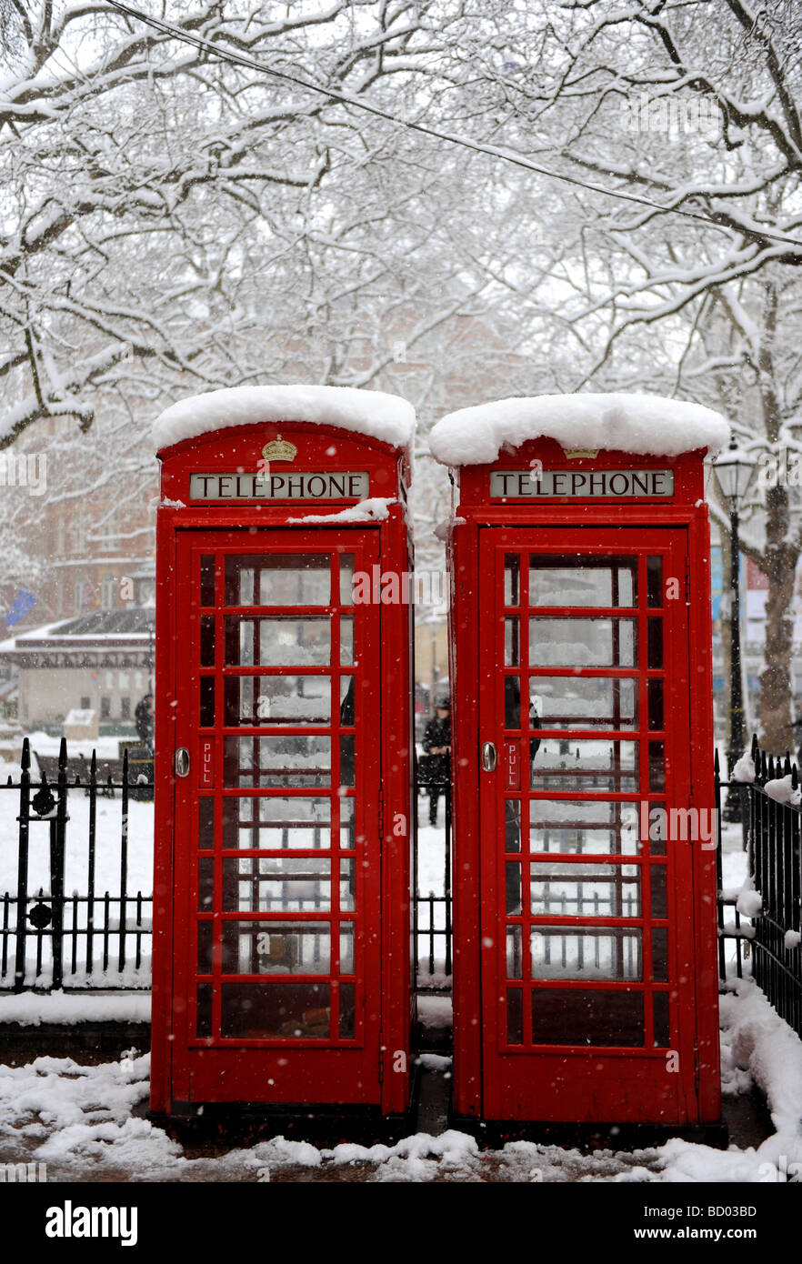 Red telephone boxes in London covered in snow Stock Photo Alamy