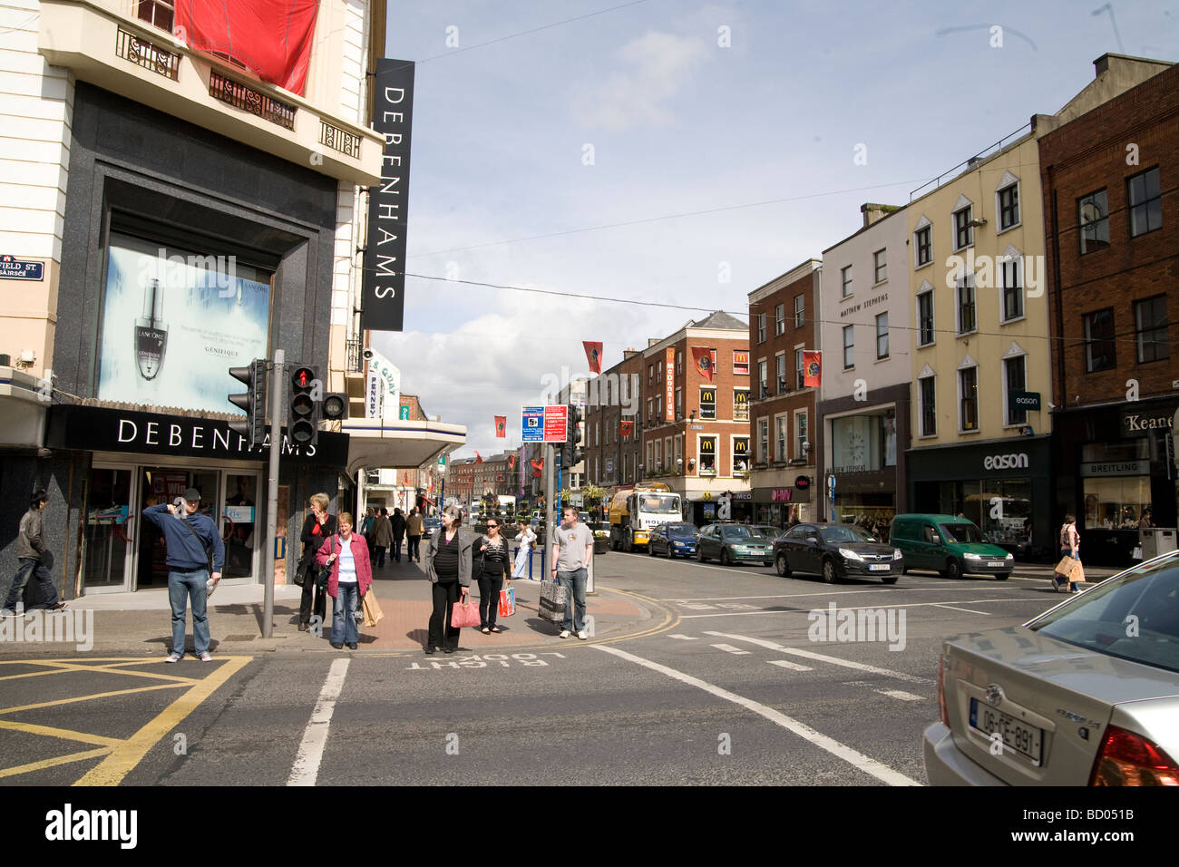 People shopping main street in Limerick Ireland outside Debenhams