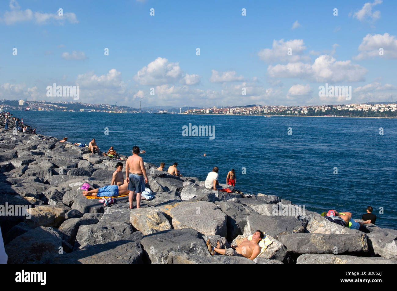 People Sunbathing Along the Sea Stock Photo