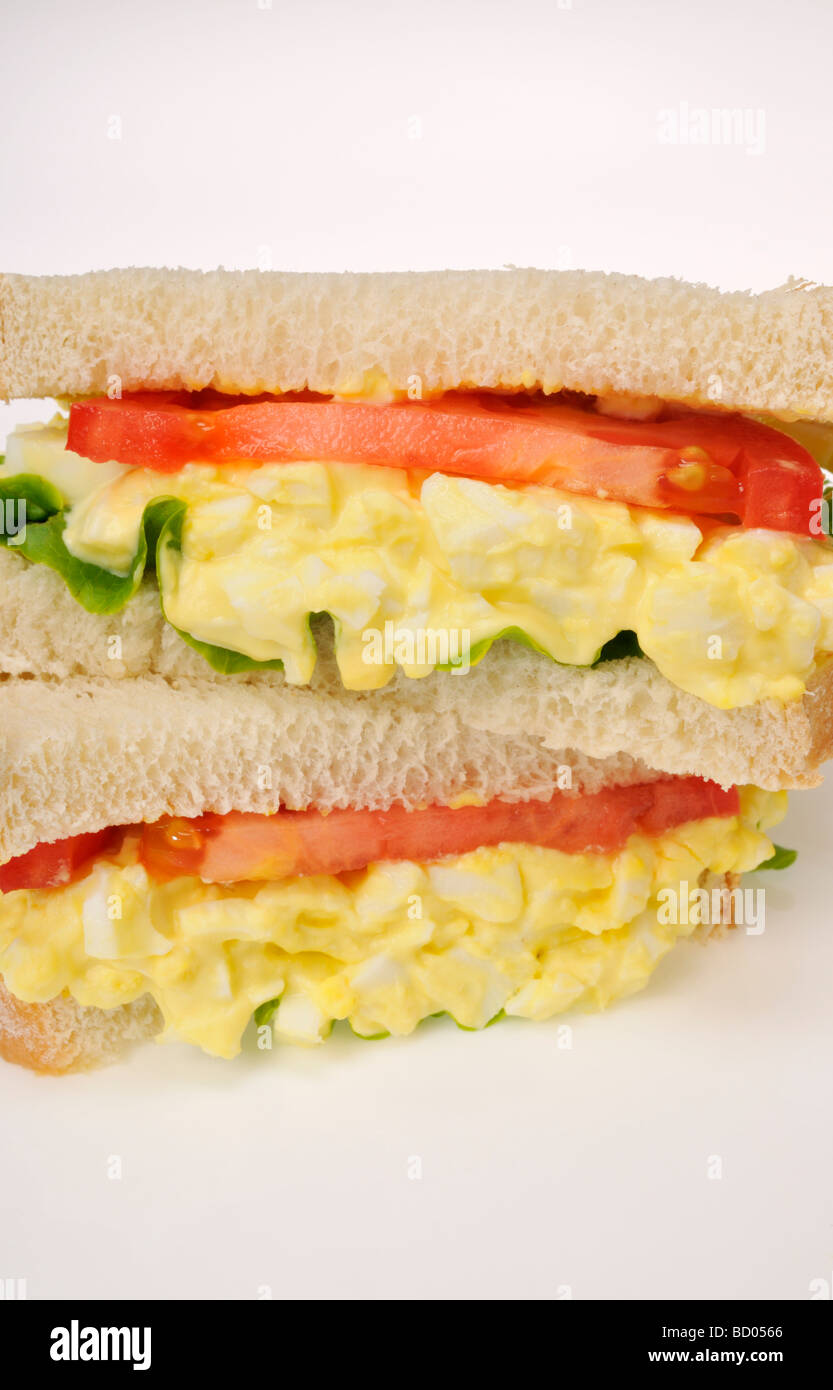 Close up of egg mayo sandwich with lettuce and tomato on white bread on white background. Stock Photo