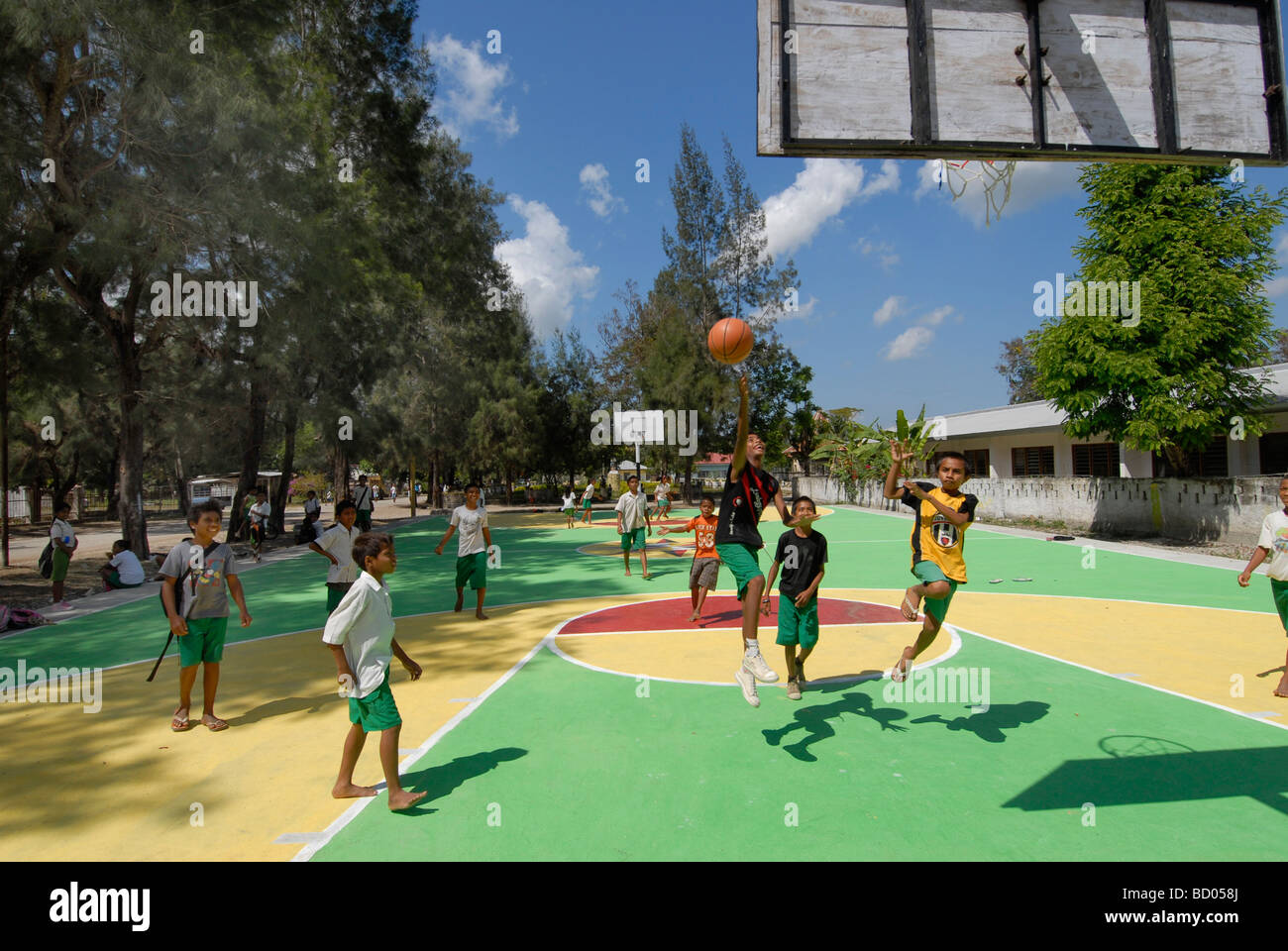 Schoolchildren playing on a basketball court built with foreign aid in