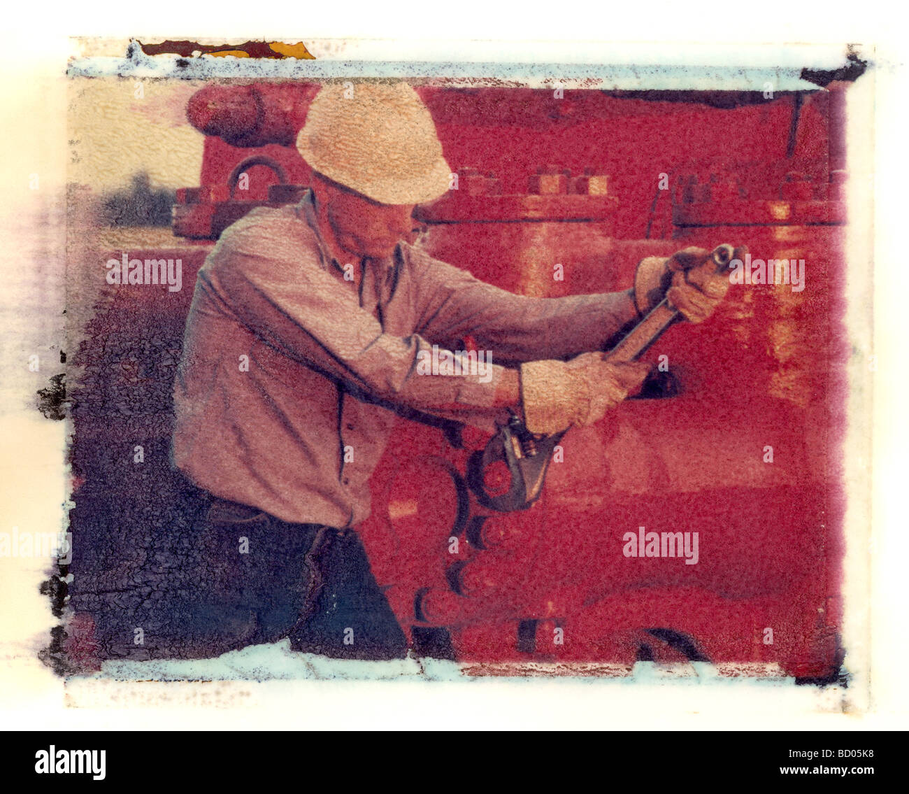 Oil industry worker tightening bolts on pump at a drilling rig image is