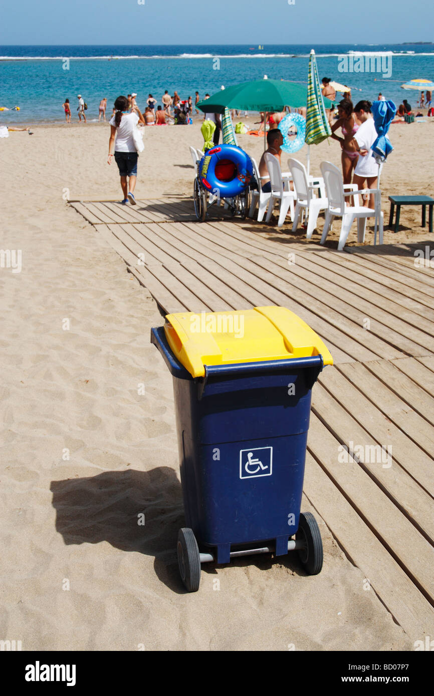 Small Wheelie bin with disabled sticker near wheelchair accessible area of beach in Spain Stock Photo