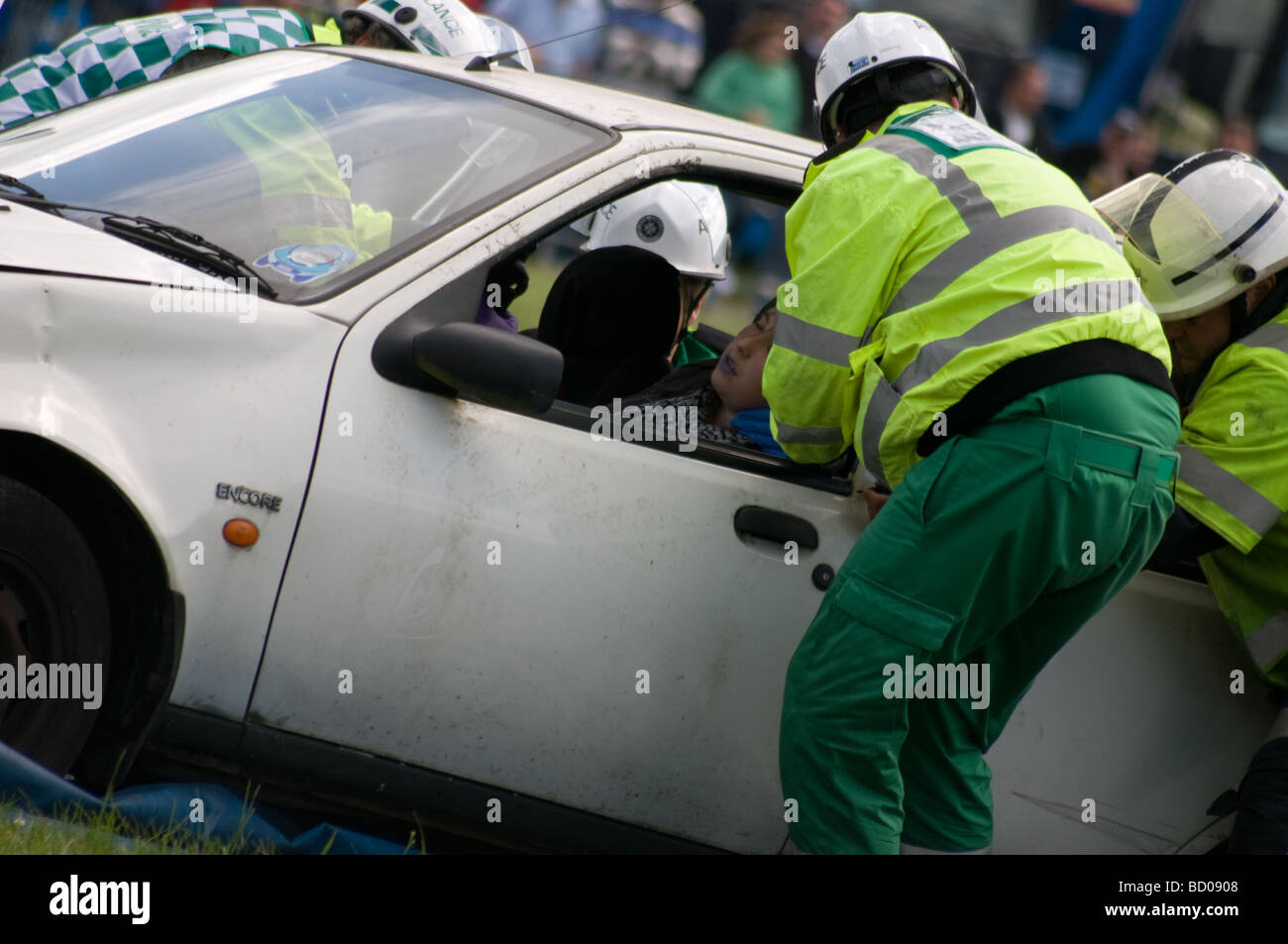Ambulance crew attending a traffic accident, the girl in the front of the car is acting as this is a demonstration, Stock Photo