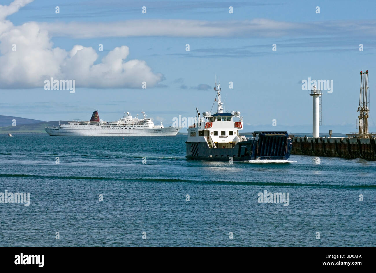 Car ferry Sharpinsay returning to Kirkwall harbour with cruise ship Mona Lisa anchored in the bay Stock Photo