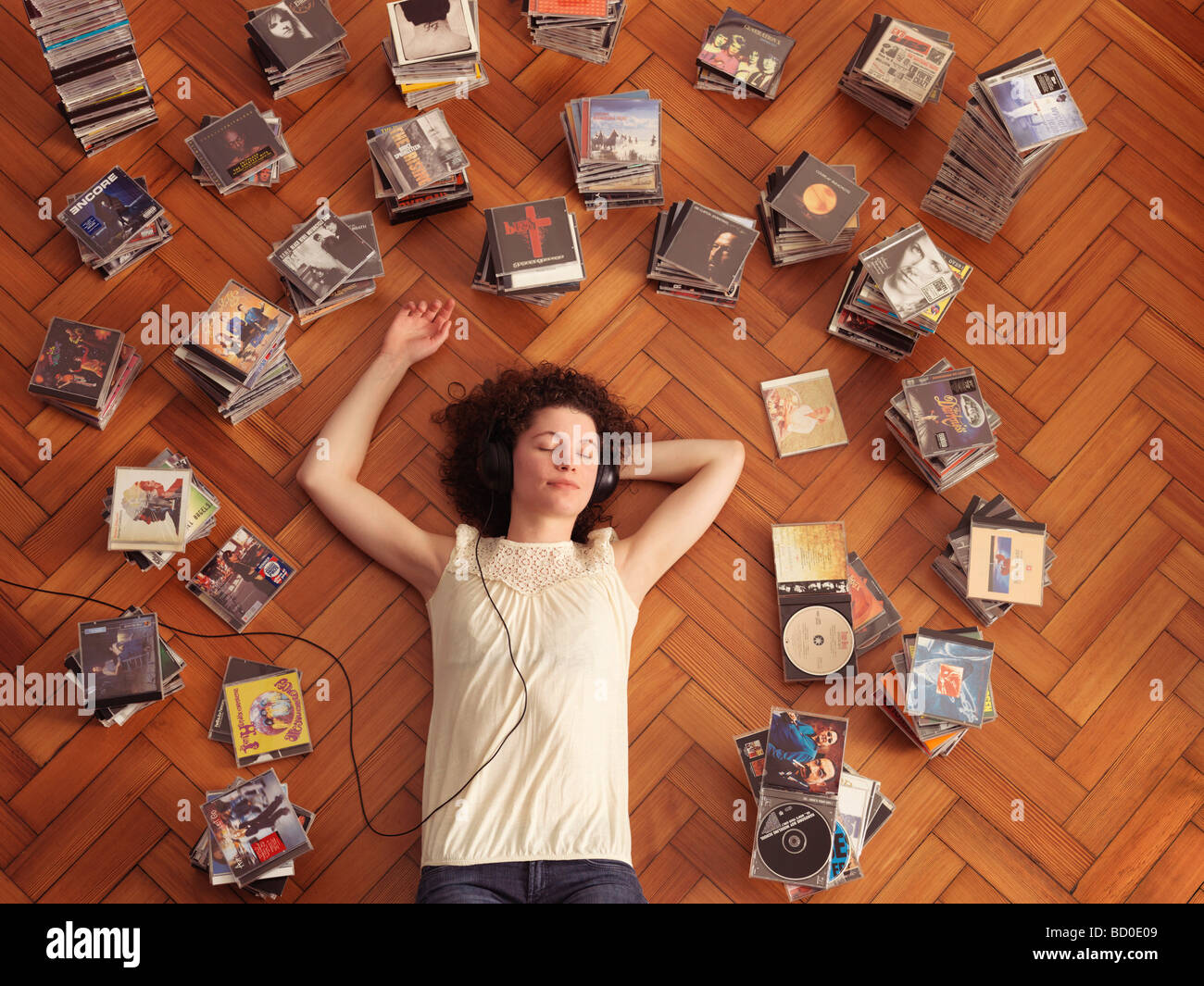 Woman lying on floor, listening to music Stock Photo - Alamy