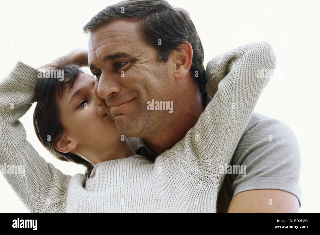 Girl kissing her father on cheek Stock Photo