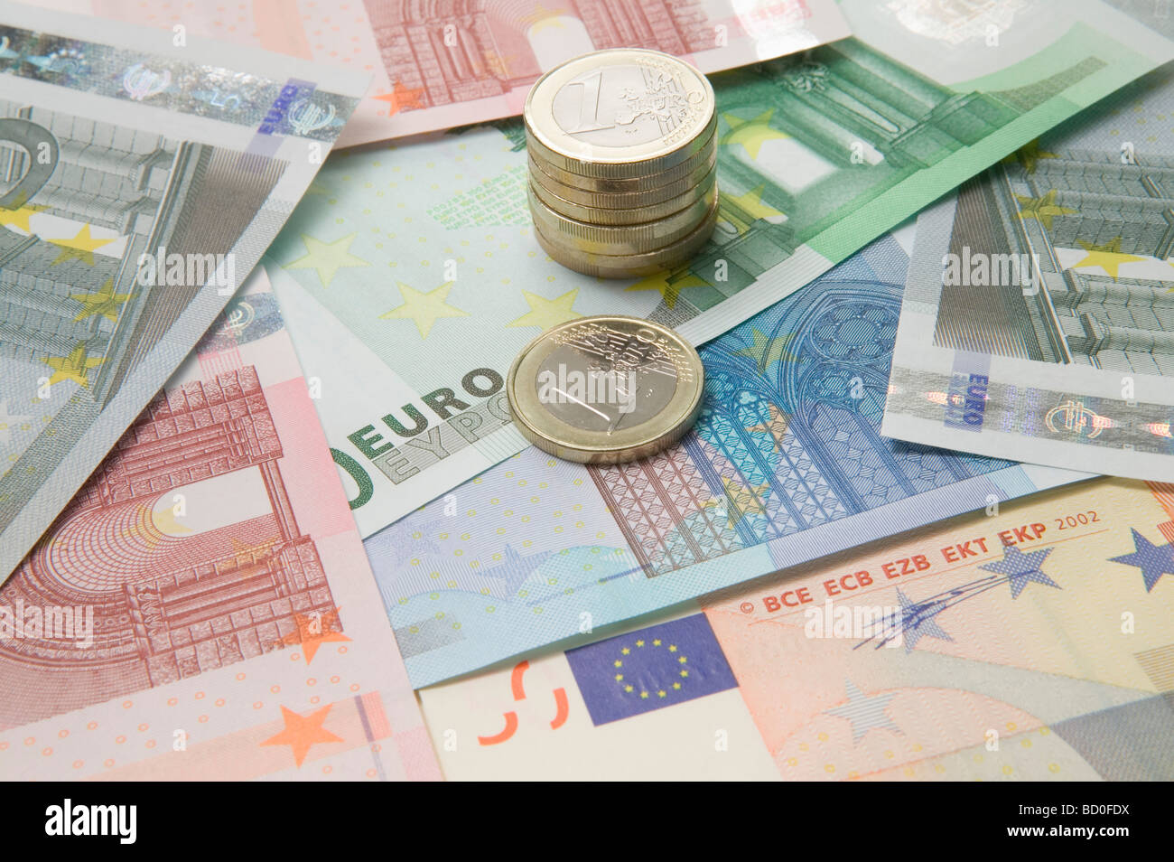 Euro currency and a stack of coins Stock Photo - Alamy