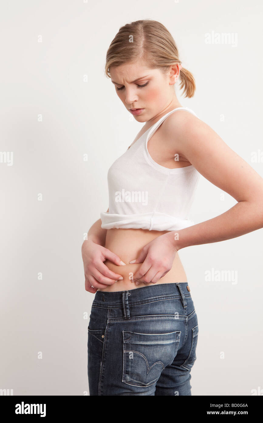 Woman pinching skin on her midriff Stock Photo