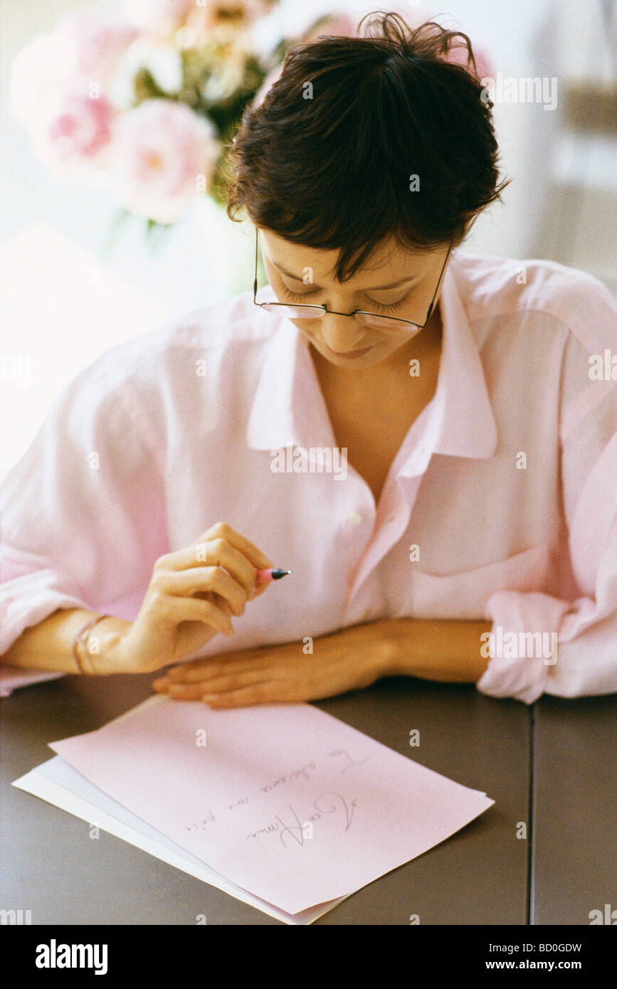 Woman writing and reviewing correspondence Stock Photo