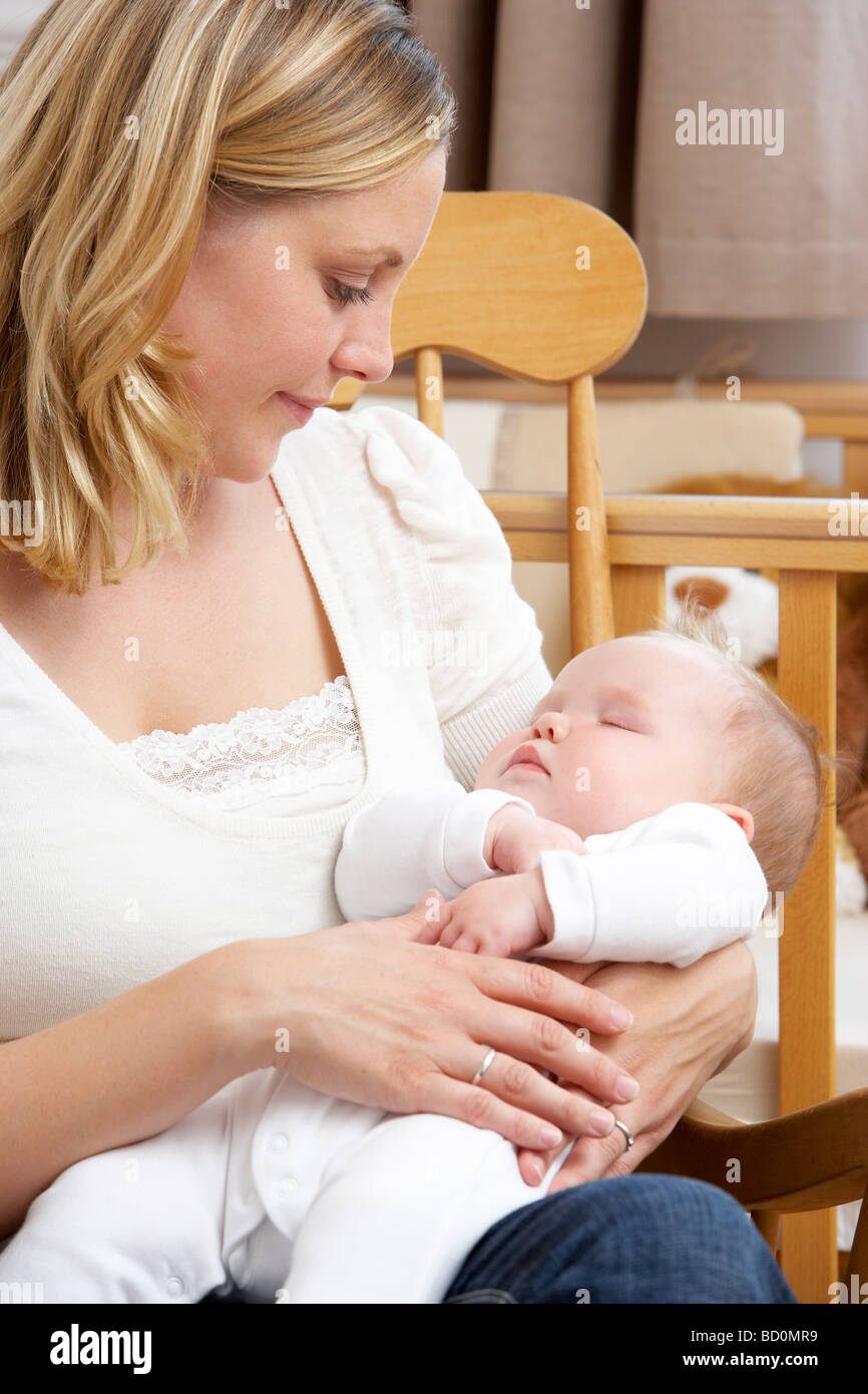 Mother Holding Baby In Nursery Stock Photo