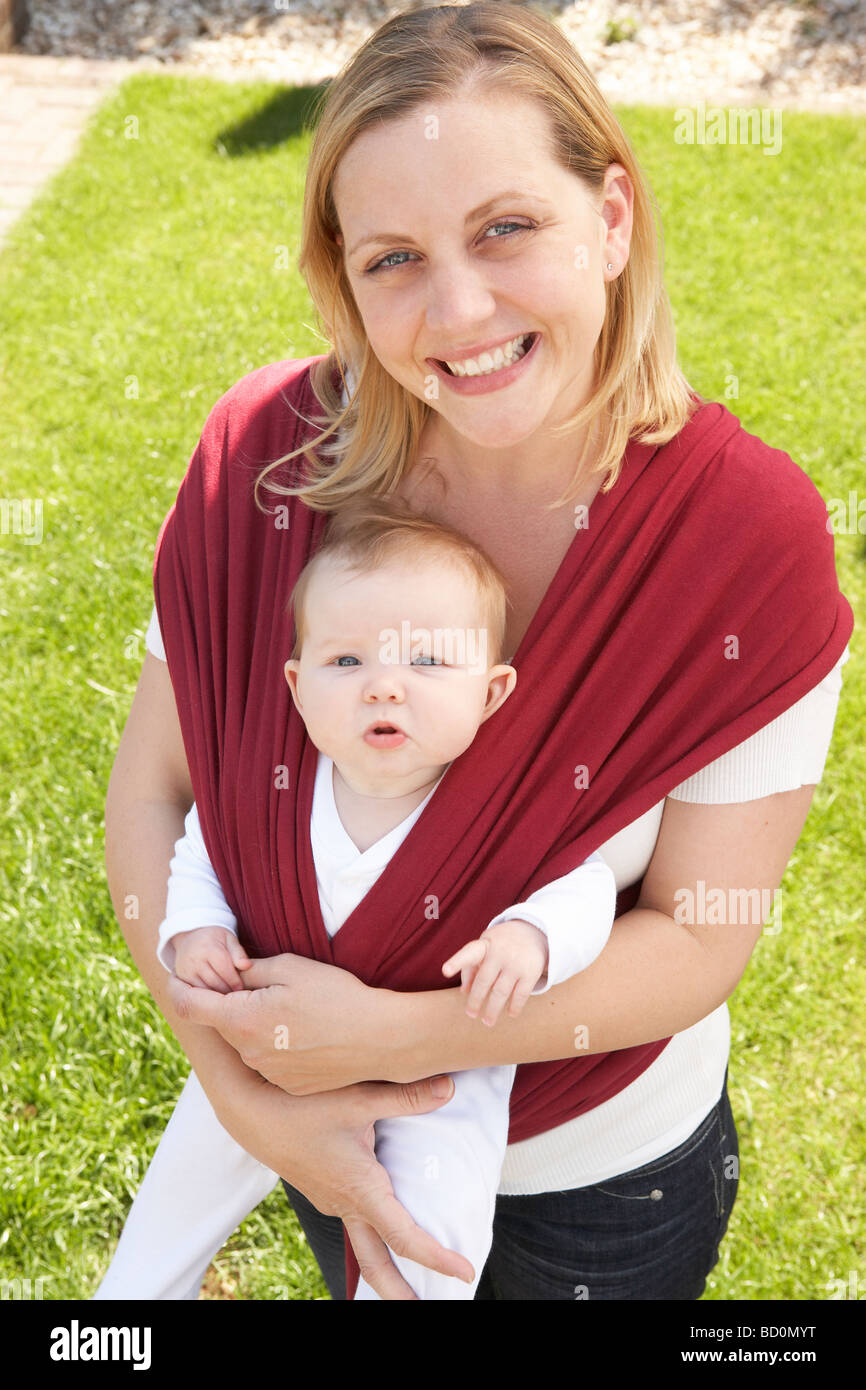 Baby In Sling With Mother Outdoors Stock Photo