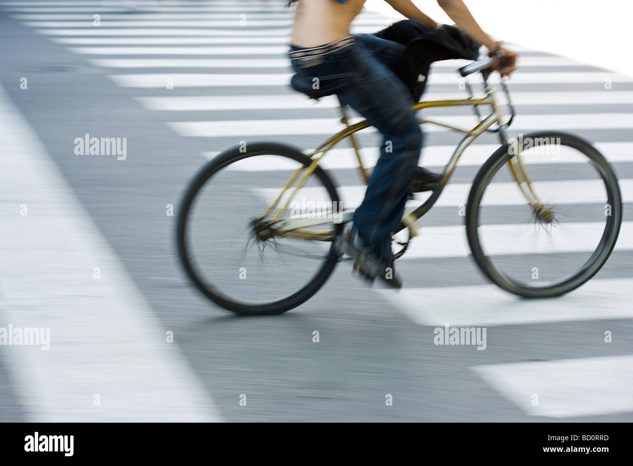 Person riding bicycle over crosswalk Stock Photo