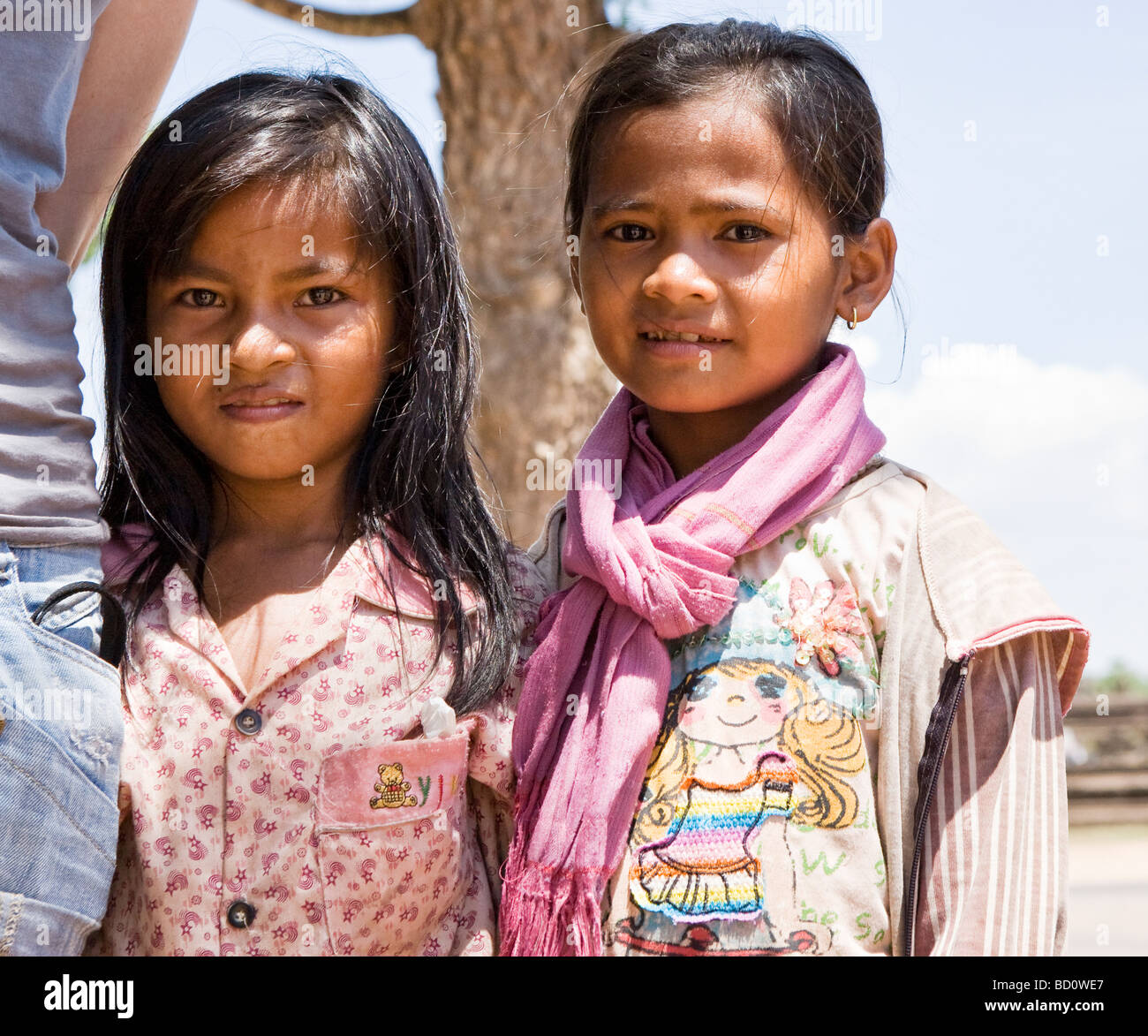 Two young girls selling souvenirs outside Angkor Wat Stock Photo