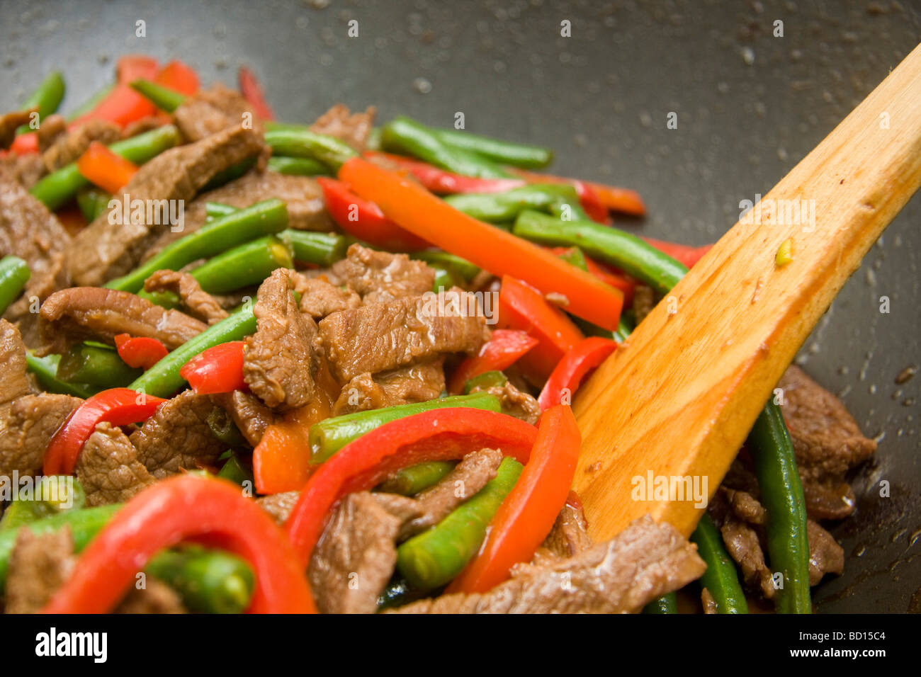 Stir fry in wok beef beans capsicum Stock Photo - Alamy