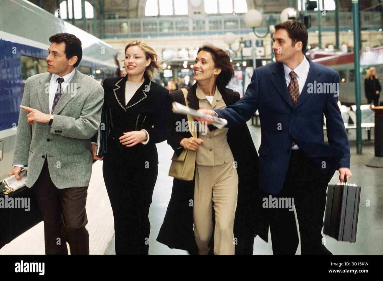 Business associates hurrying together down train platform looking for rail car Stock Photo