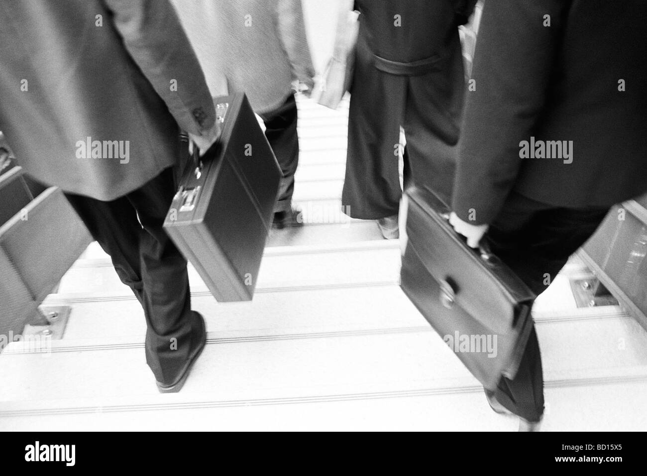 Business professionals with briefcases descending stairs Stock Photo