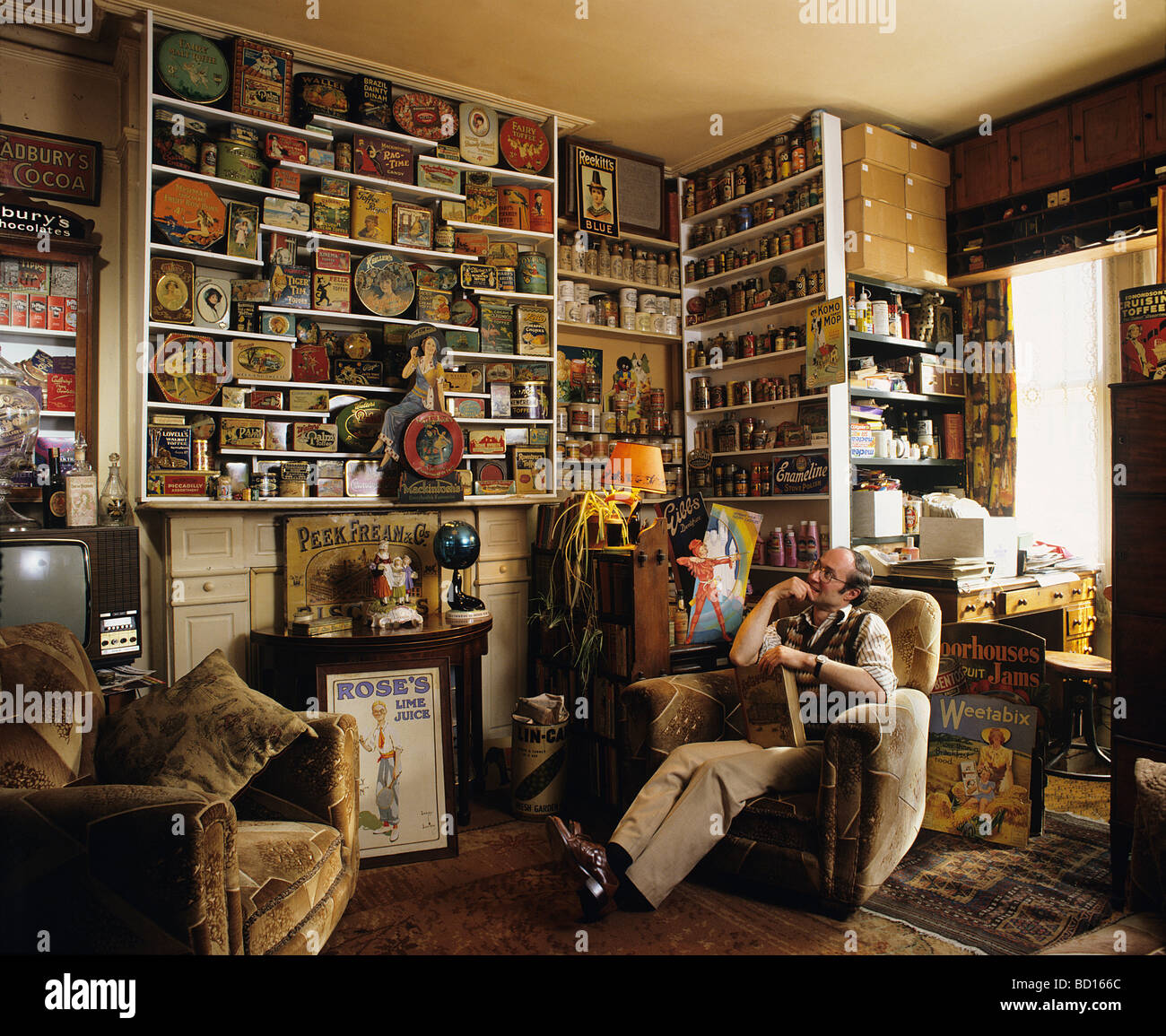 Robert Opie, collector of Advertising and Packaging, and museum curator (The Opie Collection), in his home living room. Stock Photo