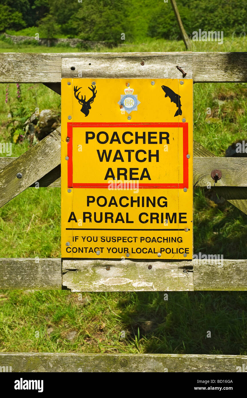 Poacher rural crime warning sign close up attached to wooden gate Cumbria Lake District National Park England UK United Kingdom GB Great Britain Stock Photo