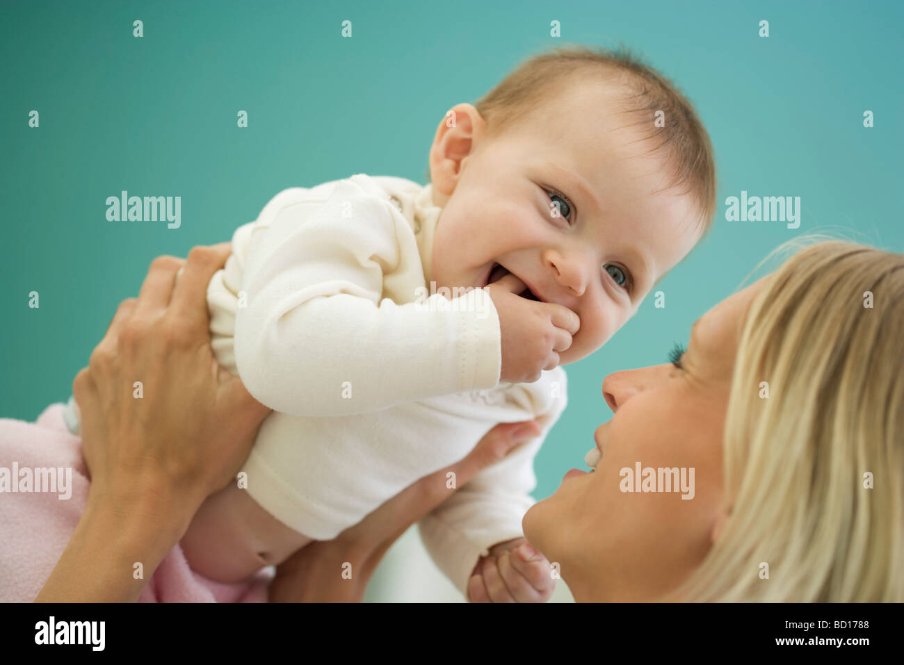 Woman picking up happy baby Stock Photo Alamy
