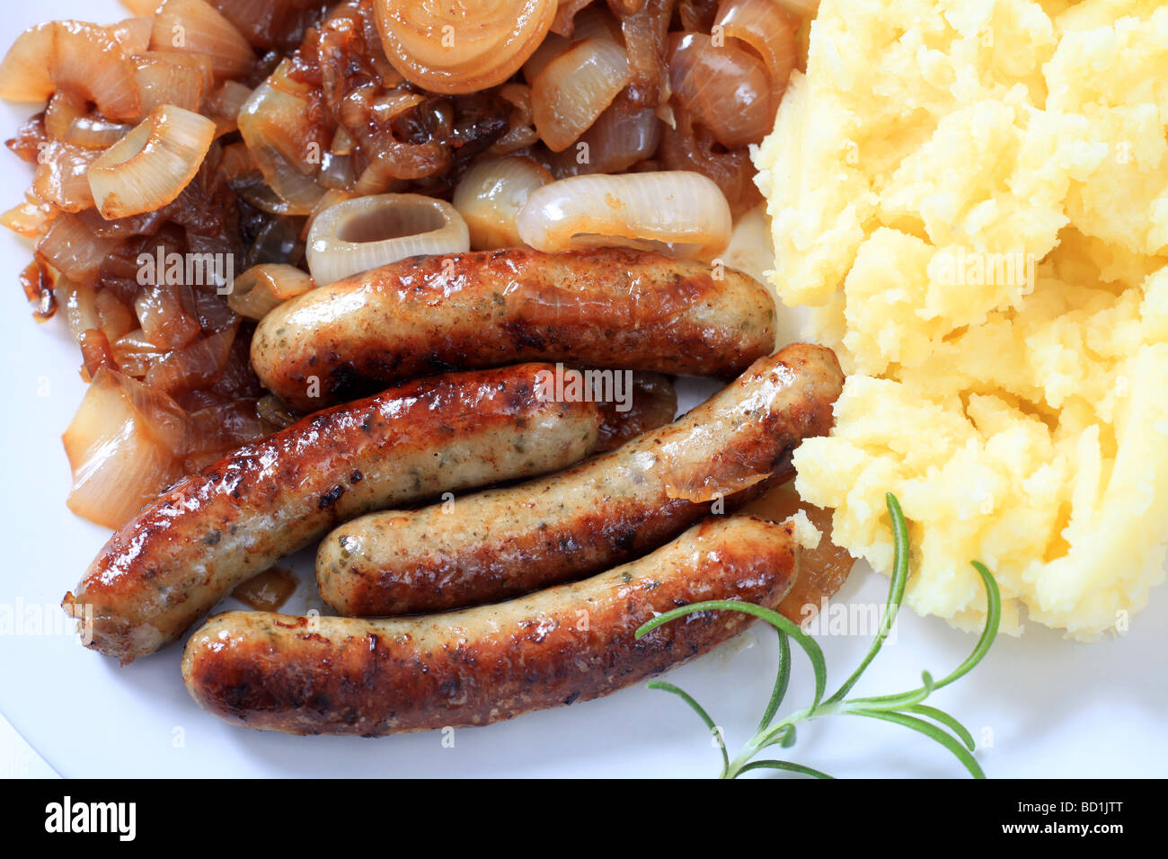 A traditional English meal of bangers and mash fried sausages with mashed potato and fried onion Stock Photo