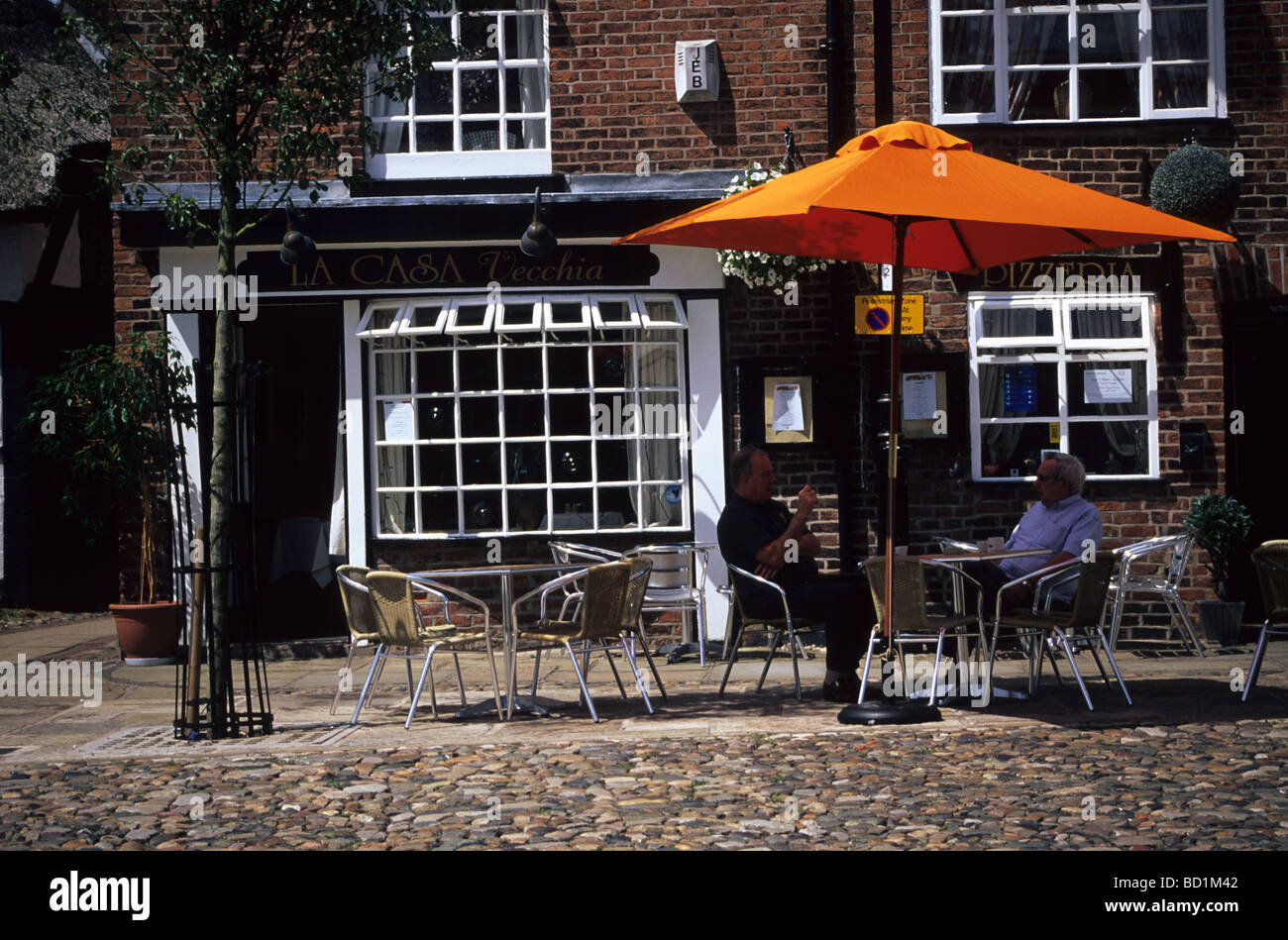 Two friends Sitting Outside An Italian Restaurant In Market Square Sandbach Cheshire Stock Photo