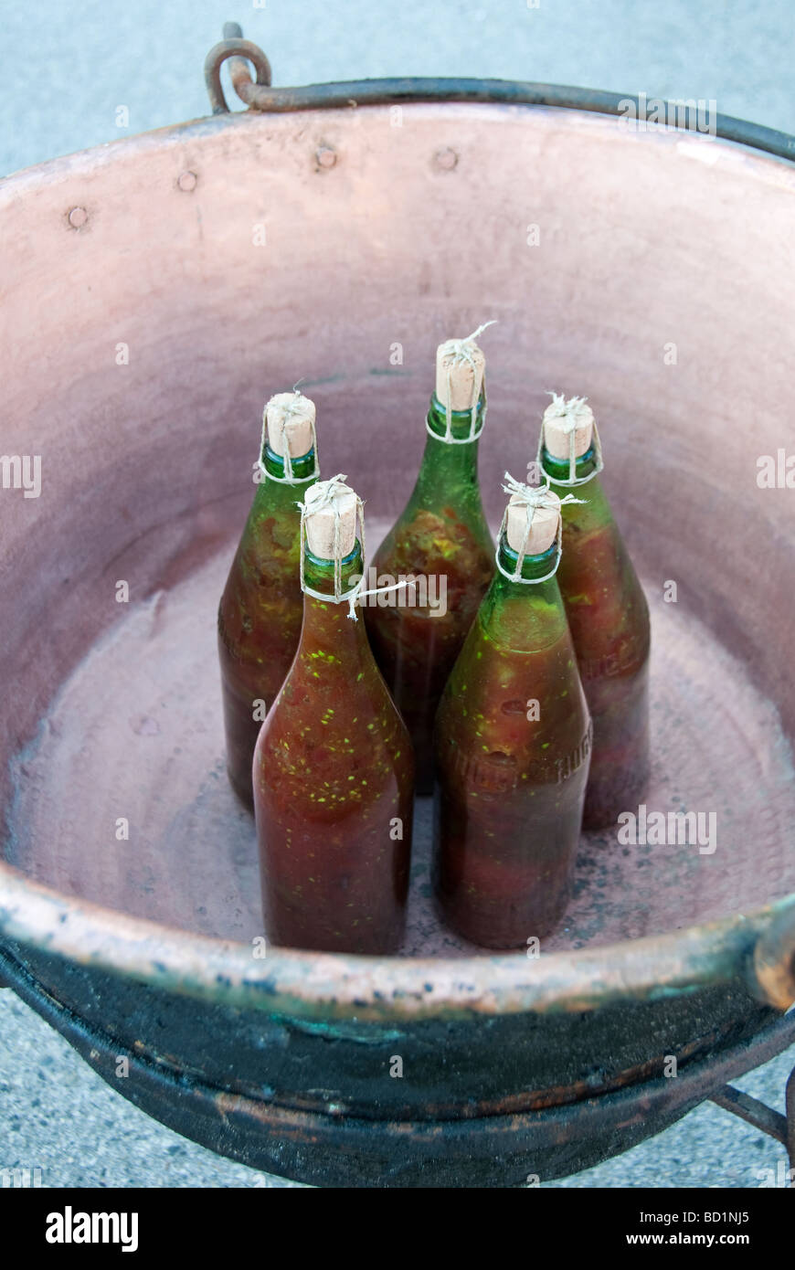 demonstration of old fashioned method for making and preserving tomato puree and bottling it Stock Photo