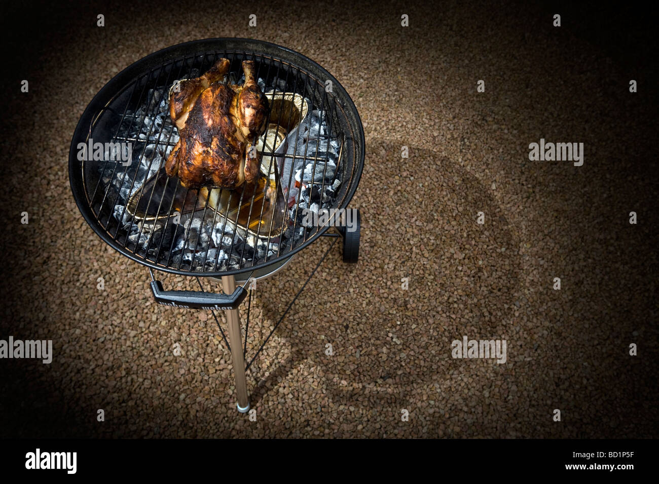 The roasting of a free-range chicken thanks to a barbecue set. Cuisson d un poulet fermier dans un barbecue à couvercle. Stock Photo