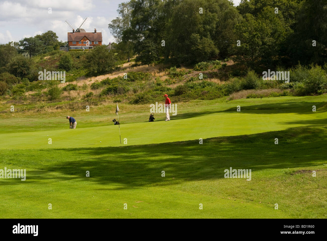 Golfers On Reigate Heath Golf Course With The Clubhouse In The