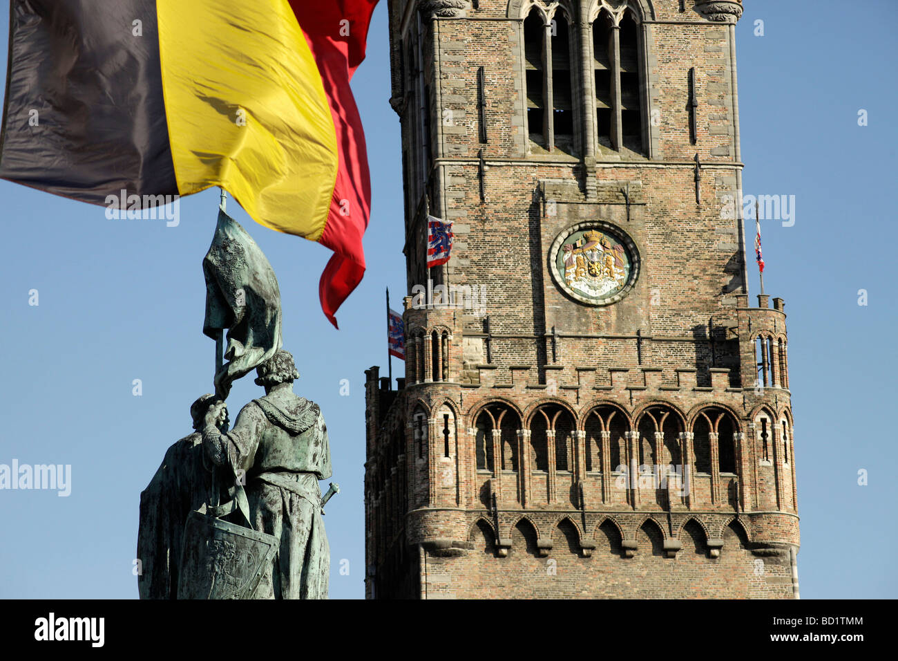 flag and the statue of the Bruges folk heroes Jan Breydel and Pieter de Coninck on the market square Grote Markt  bruges Stock Photo