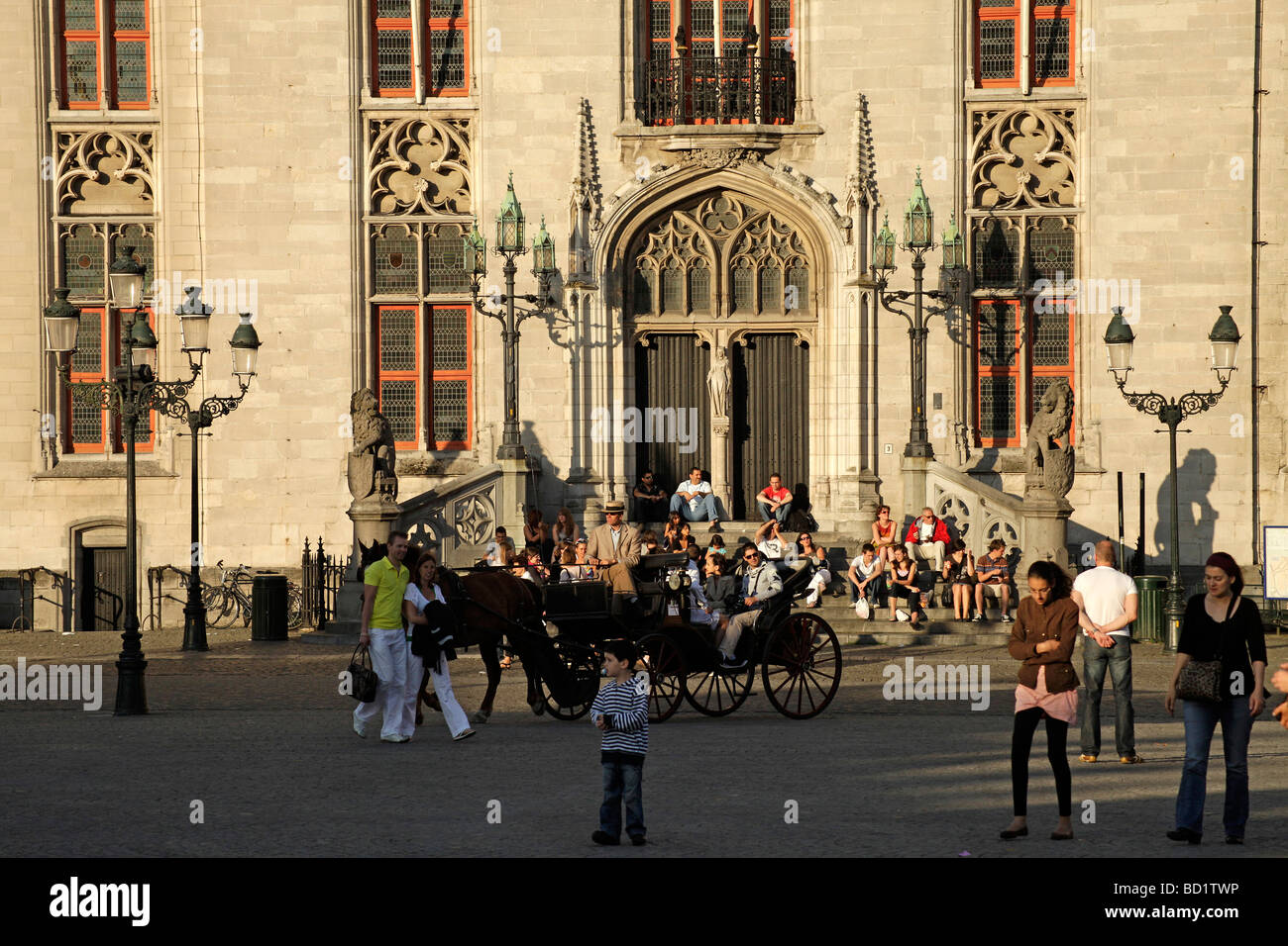 Carriage with tourists on the Grote Markt square with Provinciaal Hof Provincial Court building in  Bruges belgium Stock Photo