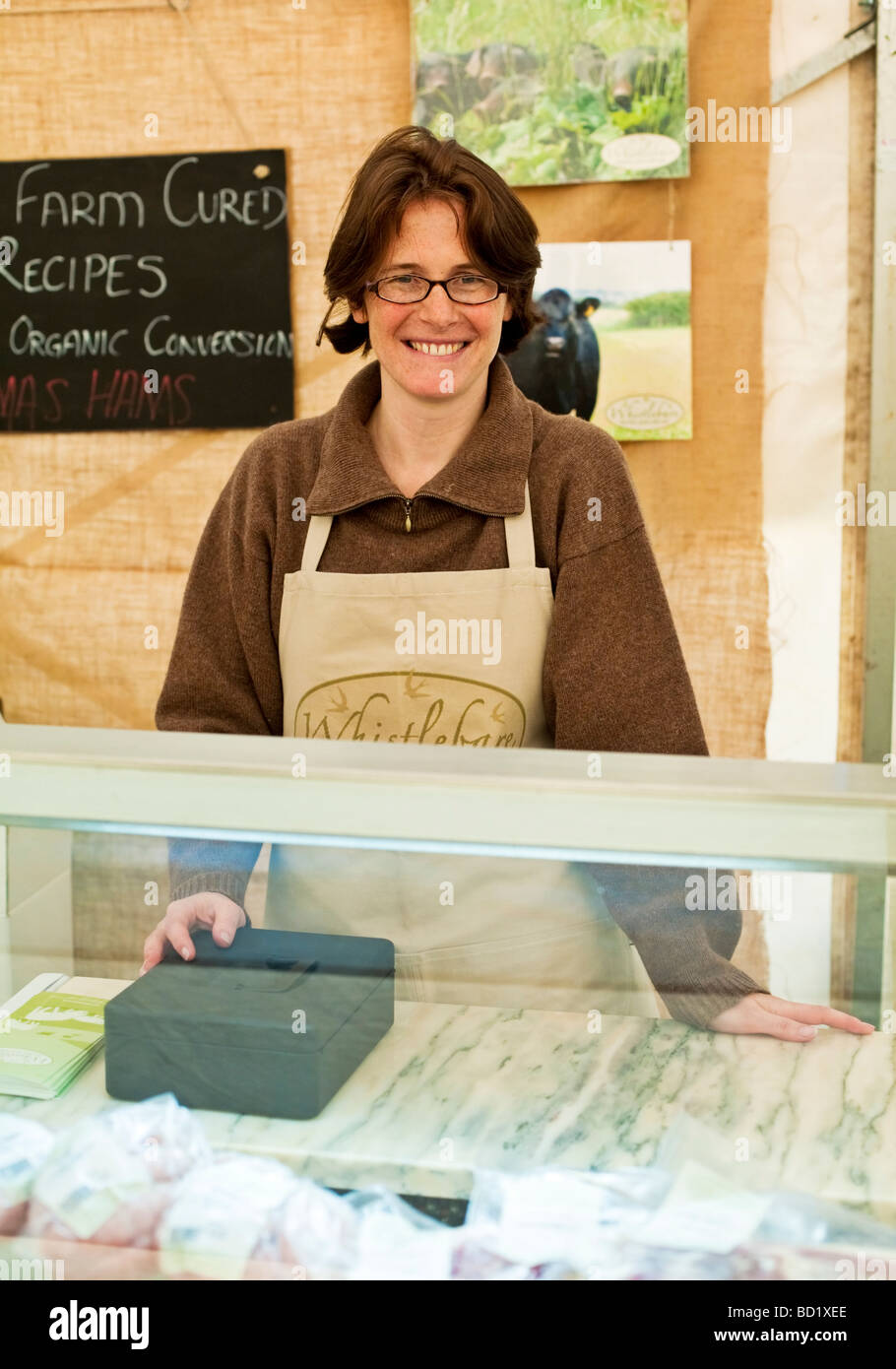 Woman selling farm cured orgainic hams at a Craft and Food Fair in Northumberland, England Stock Photo