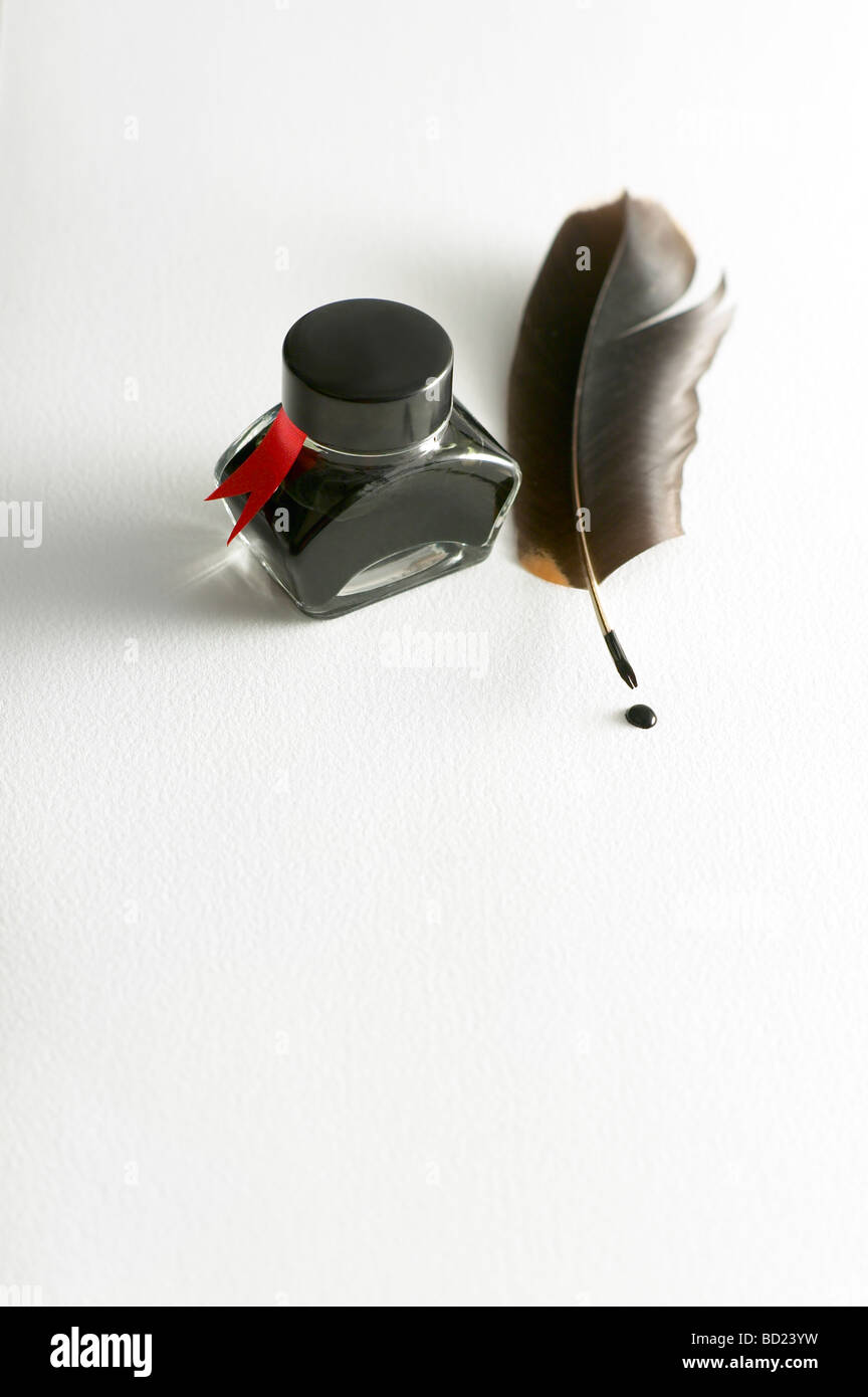 INK BOTTLE WITH QUILL PEN ON WHITE PAPER Stock Photo