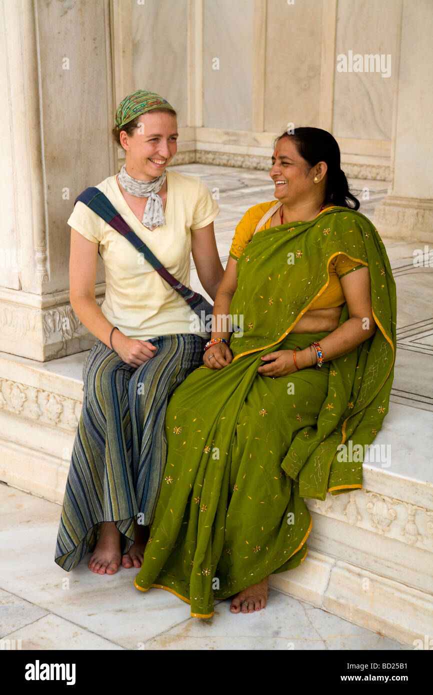 Western woman tourist sitting with an Indian woman tourist at the Nagina Masjid (ladies' mosque). Agra Red Fort, Agra. India. Stock Photo