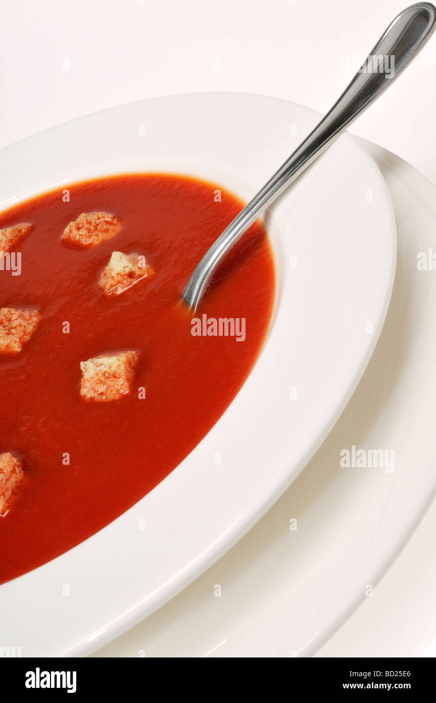 Bowl of tomato soup and croutons with spoon on white background Stock ...