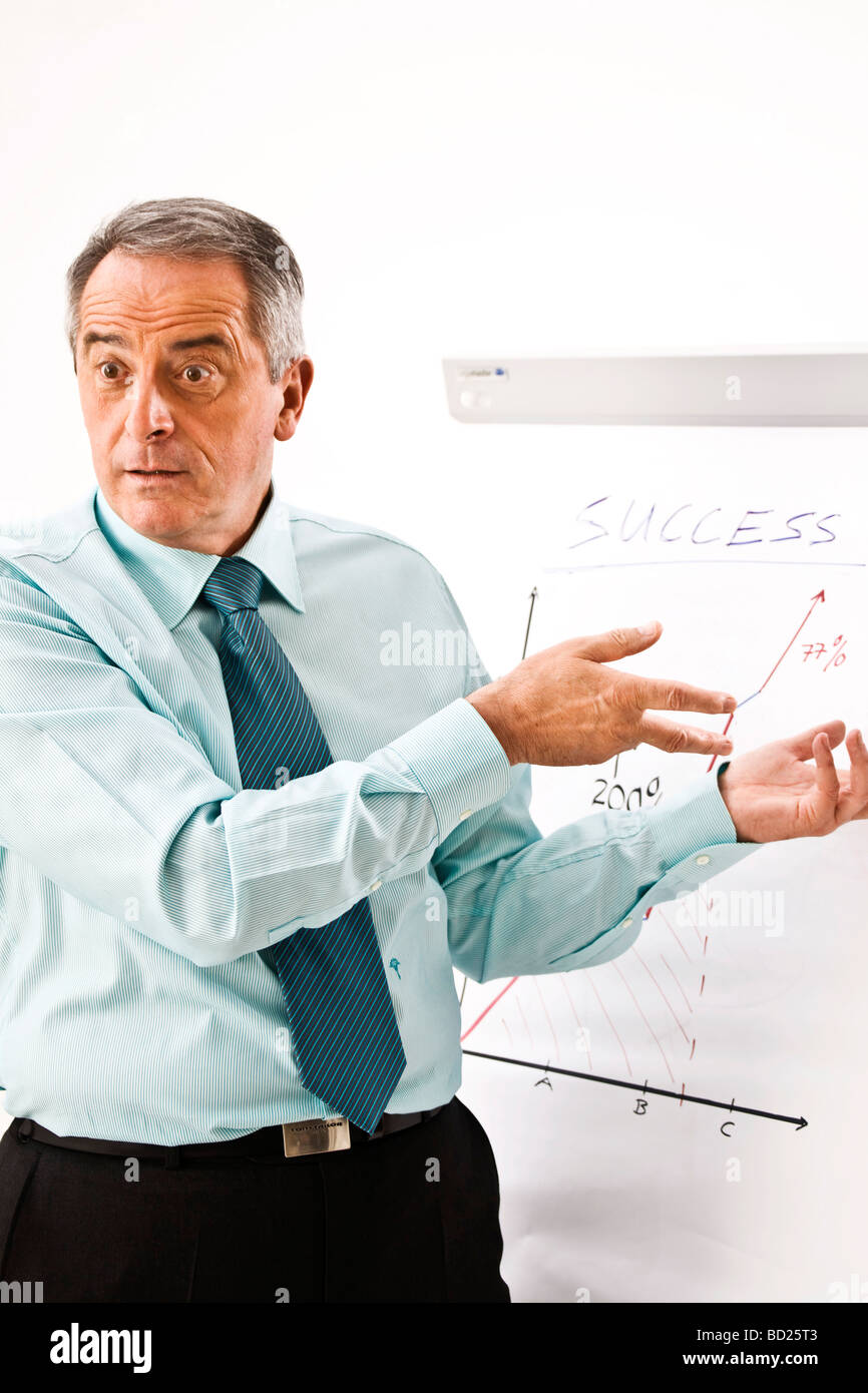 Manager pointing earnestly to his flip chart Stock Photo