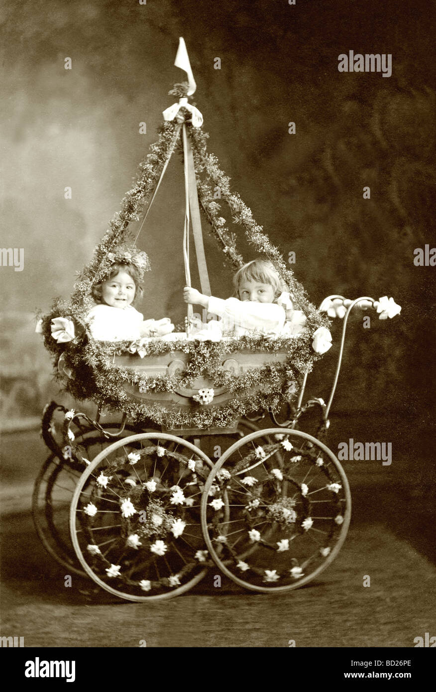 Two Infants in Floral Decorated Baby Carriage Stock Photo