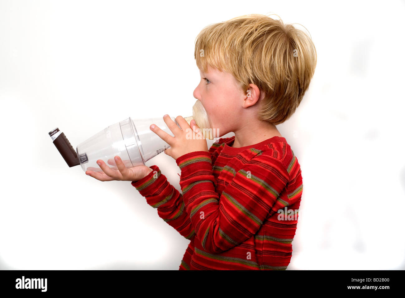 Boy using asthma inhaler with spacer device Stock Photo